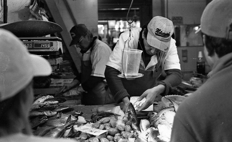 a fishmonger at a market handling fish