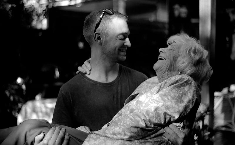 a black and white photo of a person holding their grandmother in their arms