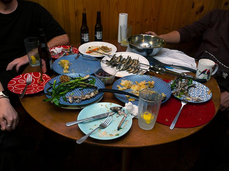 a table of empty plates of food, beer bottles and glasses