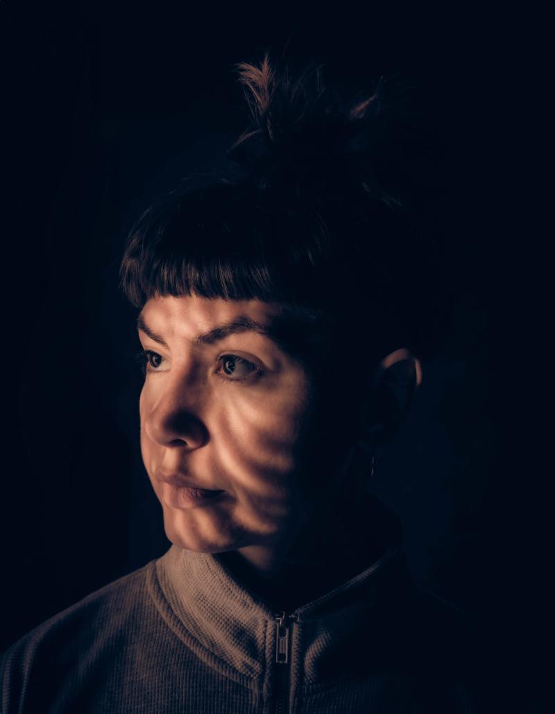 a portrait of photographer Michaela Ottone in dark lighting  