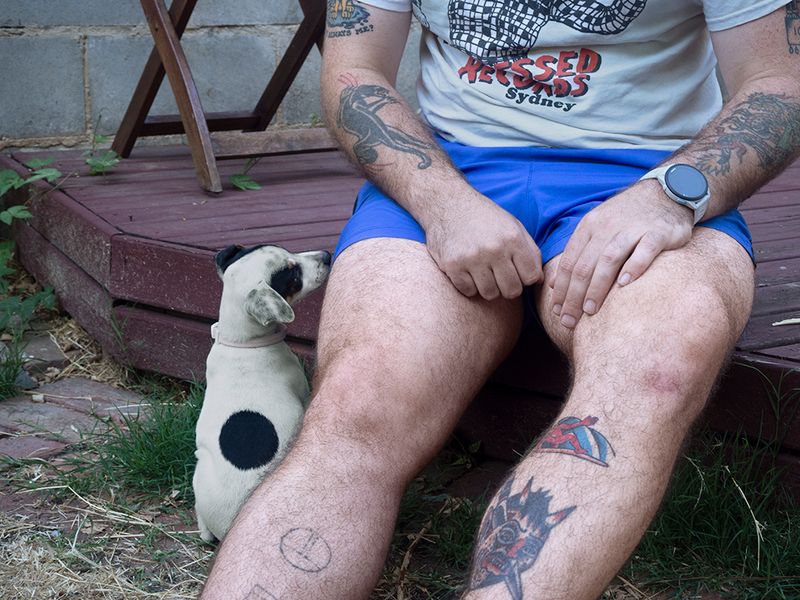 a man sitting on a deck with a puppy next to him