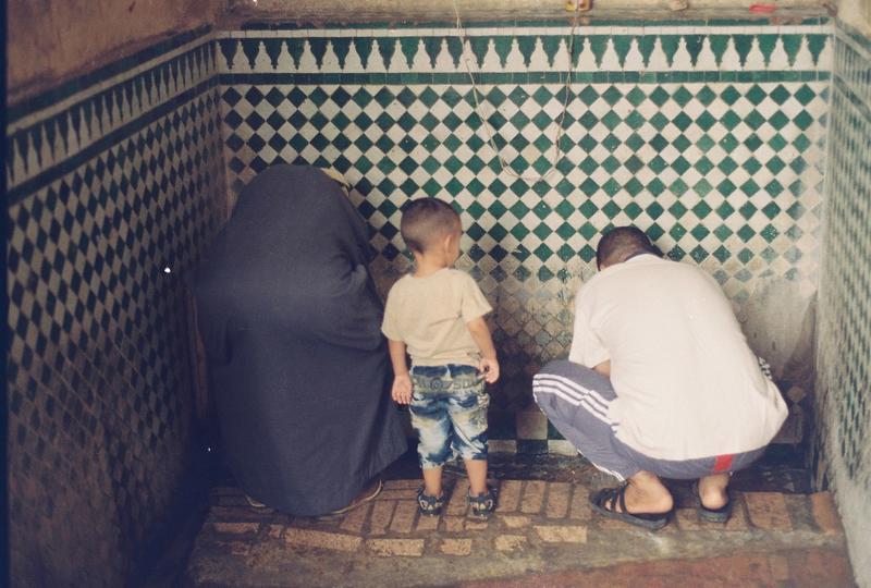 a child watches his parents washing their hands in Morocco 