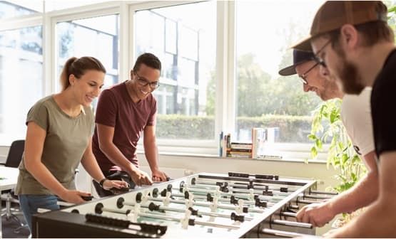 4 Personen spielen Kicker