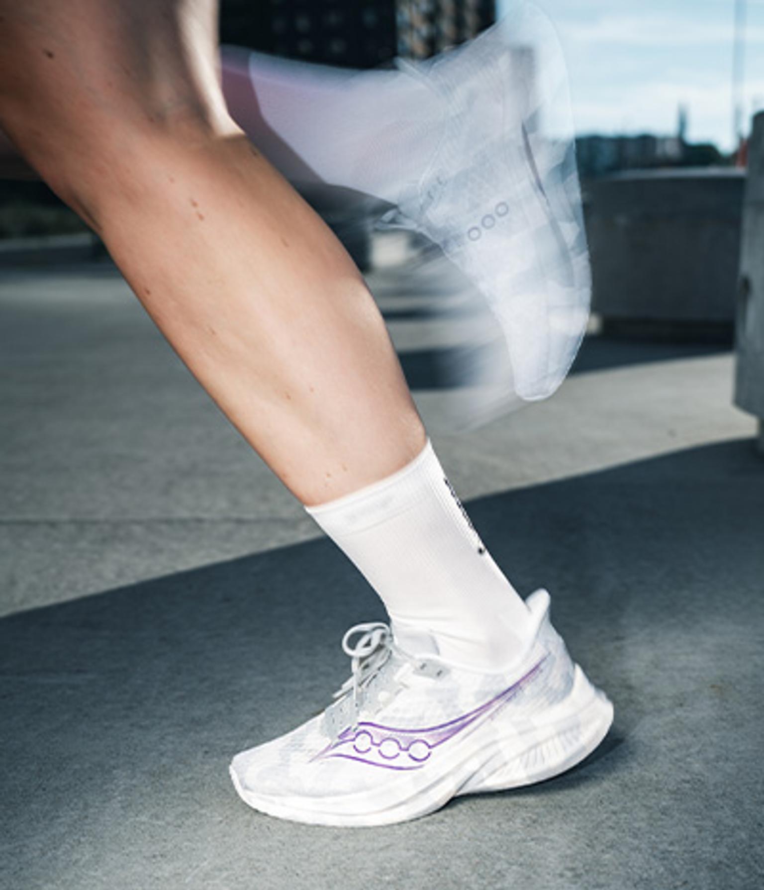 a person wearing white socks and white shoes is running .