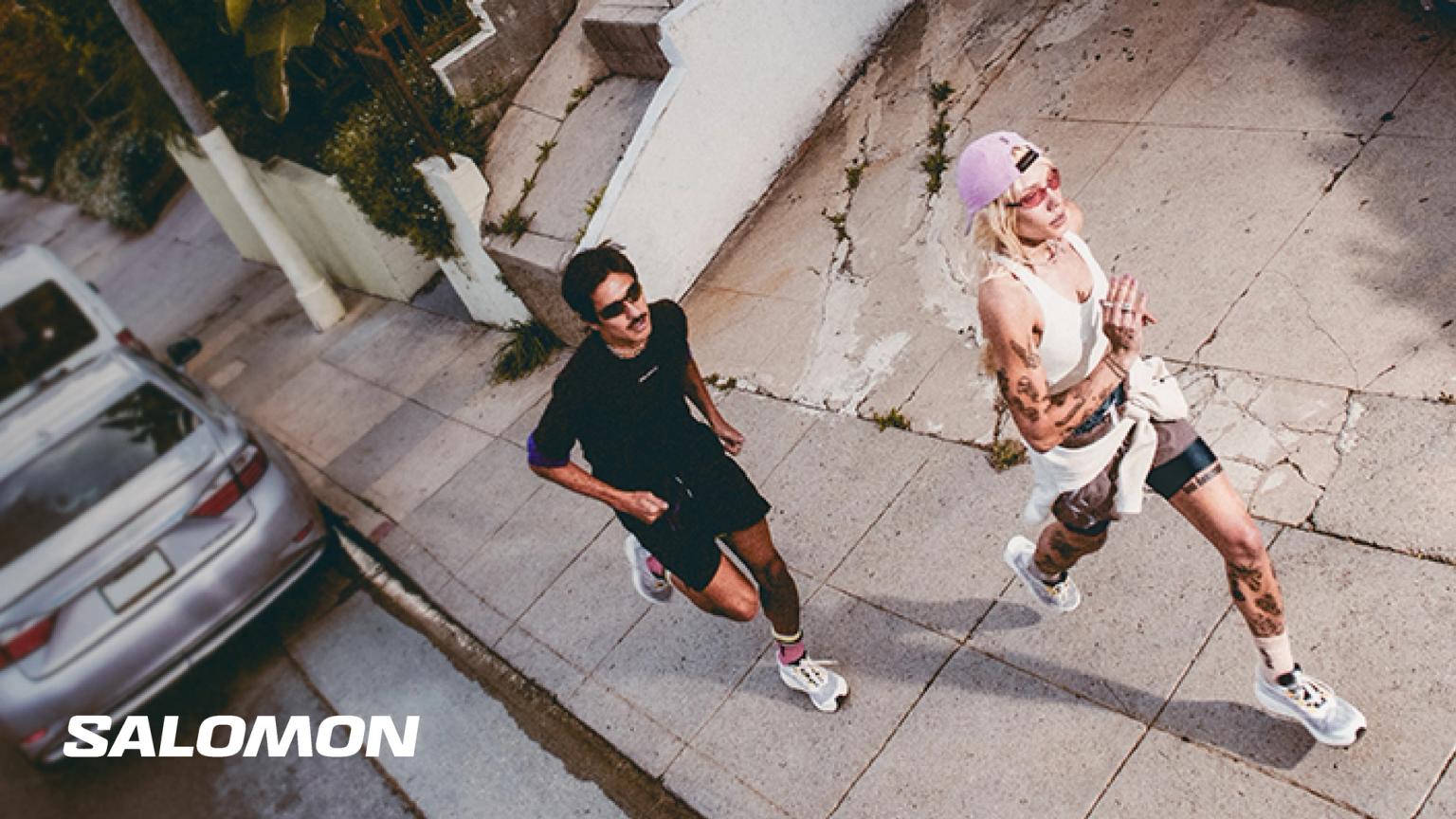 a man and a woman are running down a sidewalk .