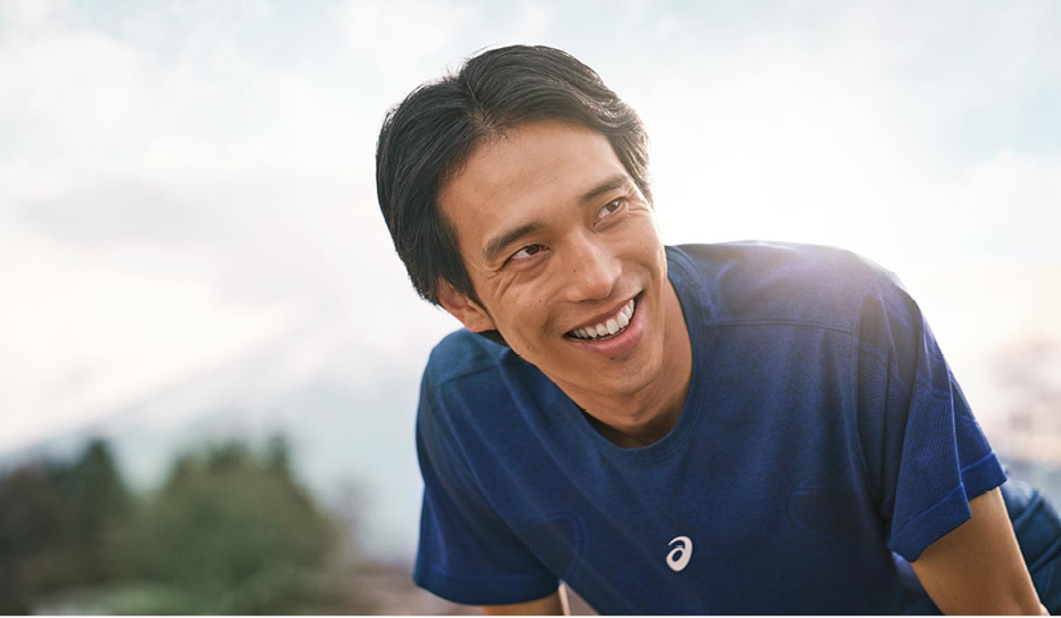 a man in a blue t-shirt is smiling and looking up .