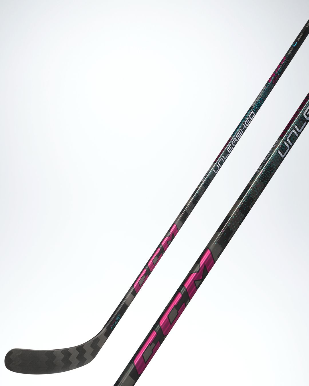 A black CCM hockey stick with pink and teal accents, "UNLEASHED" text, and a chevron pattern on the blade.
