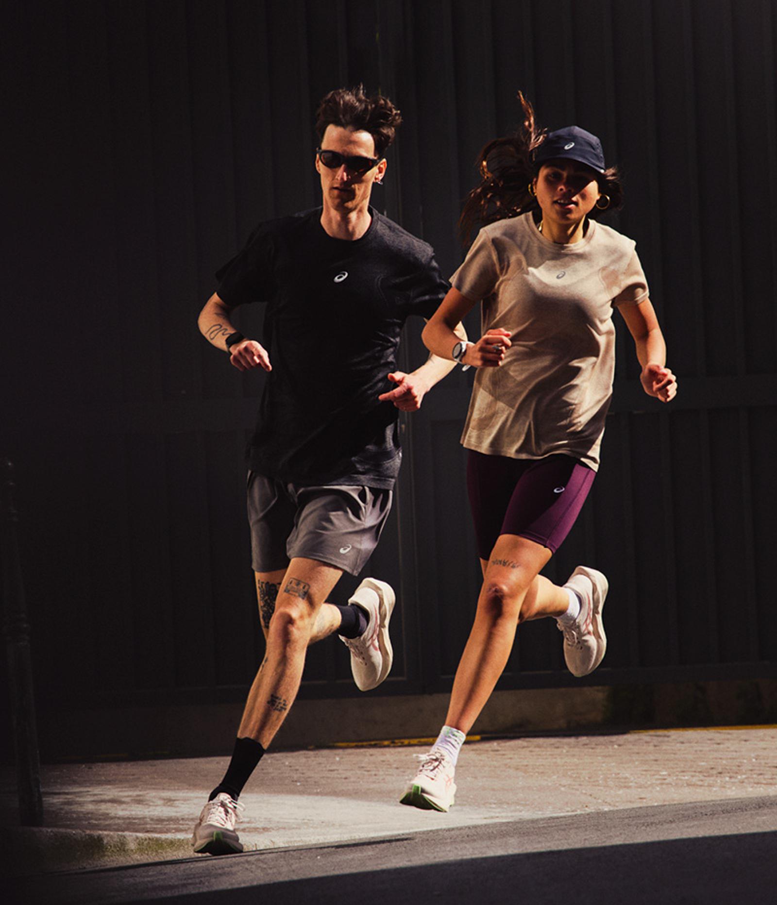 A man and woman running outdoors in athletic wear.