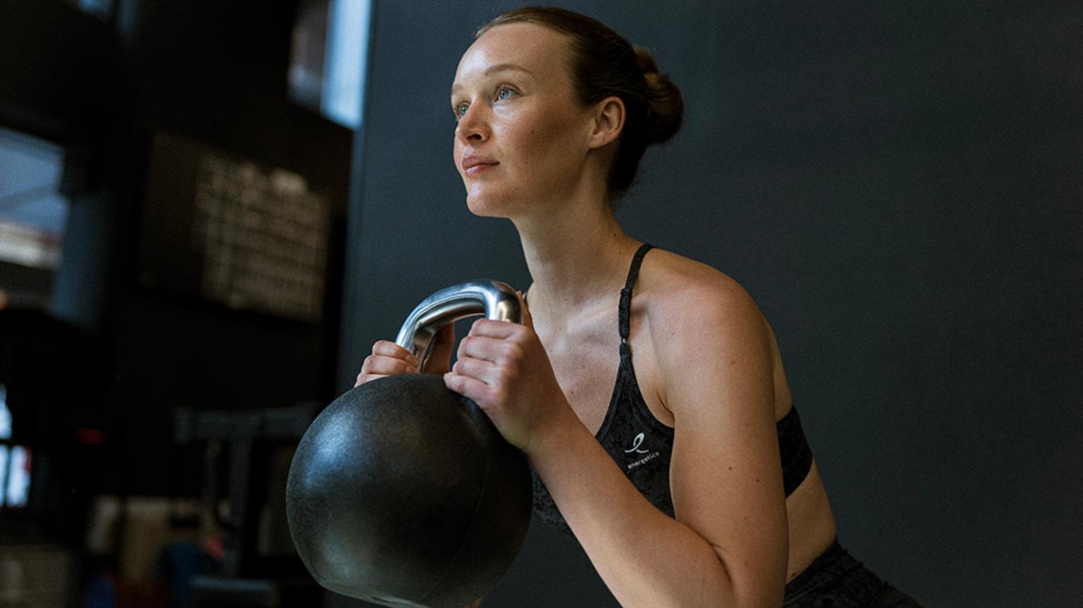 a woman is lifting a kettlebell on her workout .