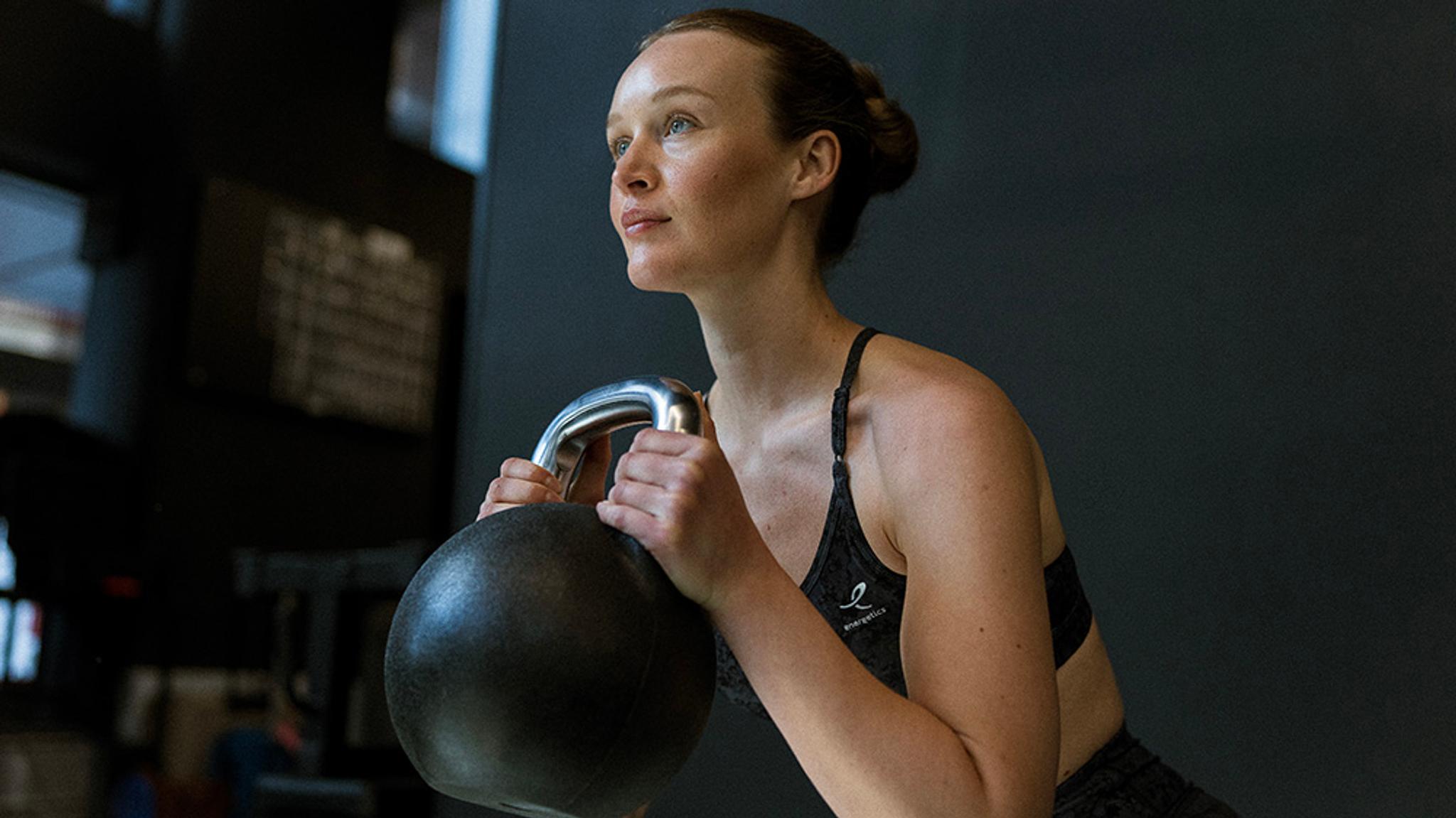 a woman is lifting a kettlebell on her workout .