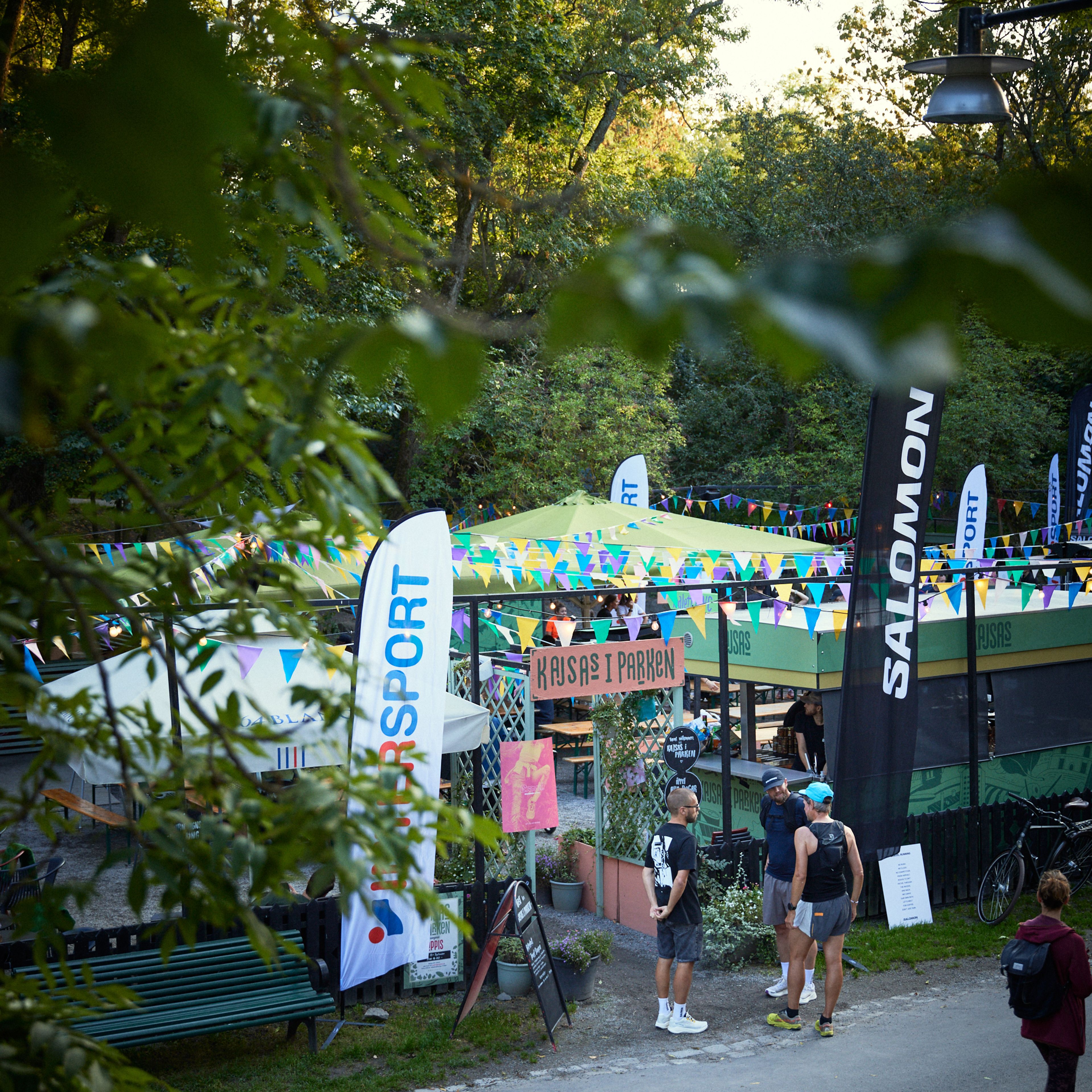 a group of people standing outside of a salomon booth