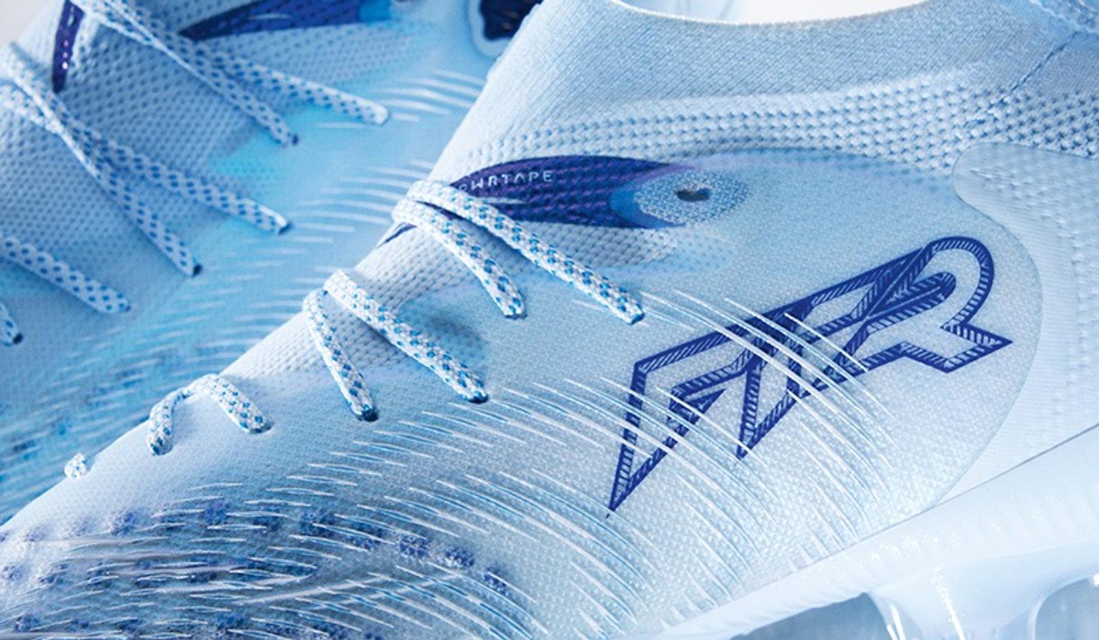Close-up of a light blue and white textured athletic shoe with blue laces and an "FR2" logo.