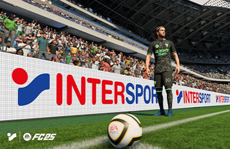 a soccer player is standing on a soccer field in front of a sign for intersport .