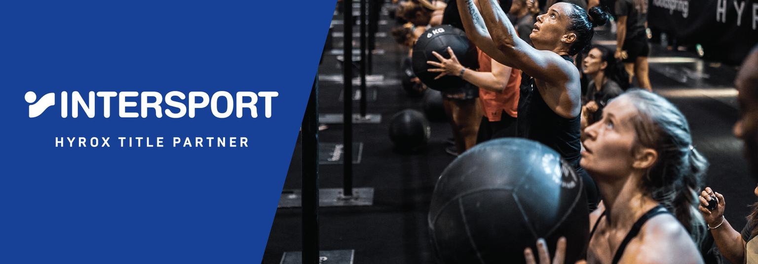 a group of women are holding medicine balls in a gym .
