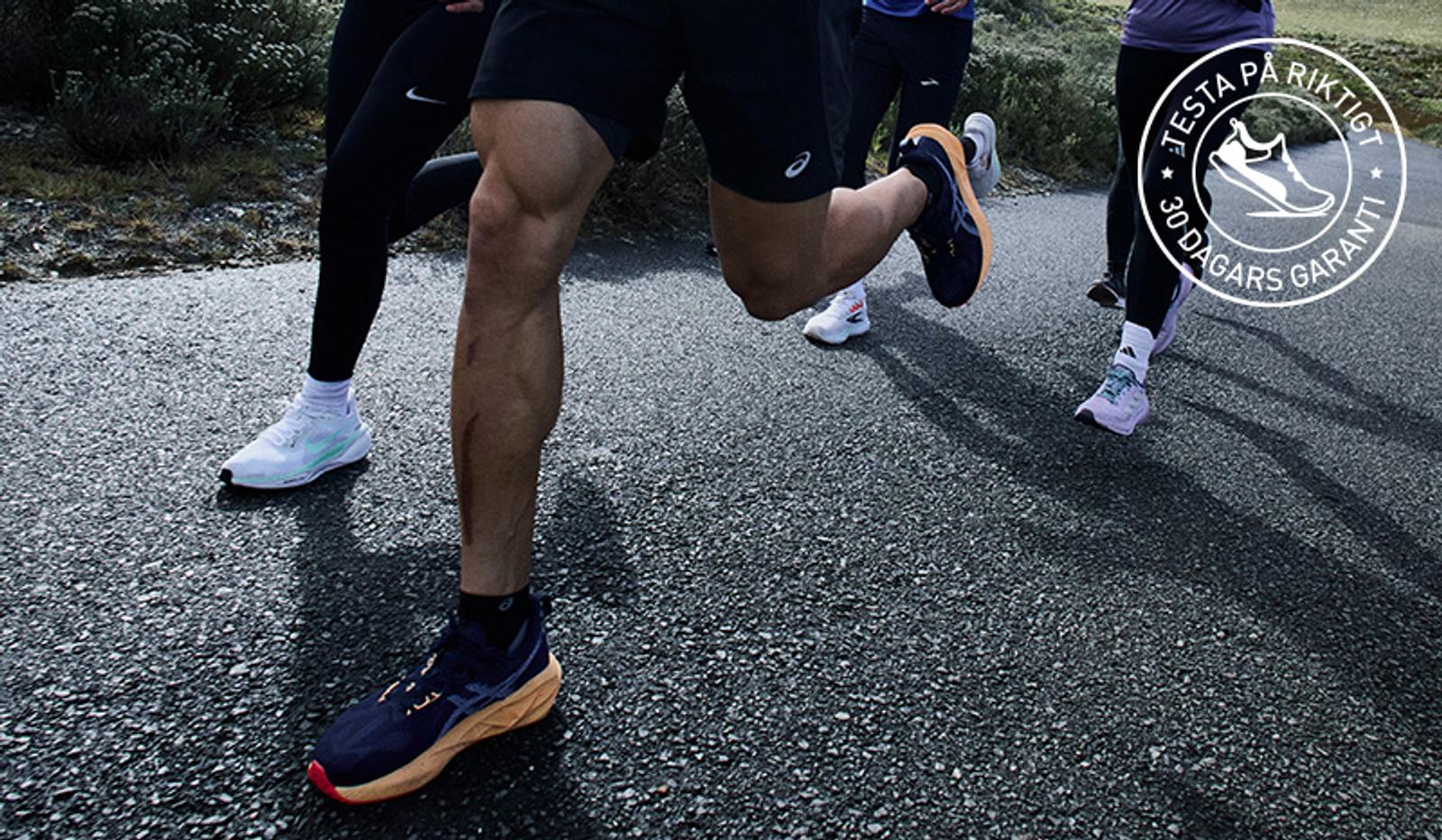 a group of people are running down a road .