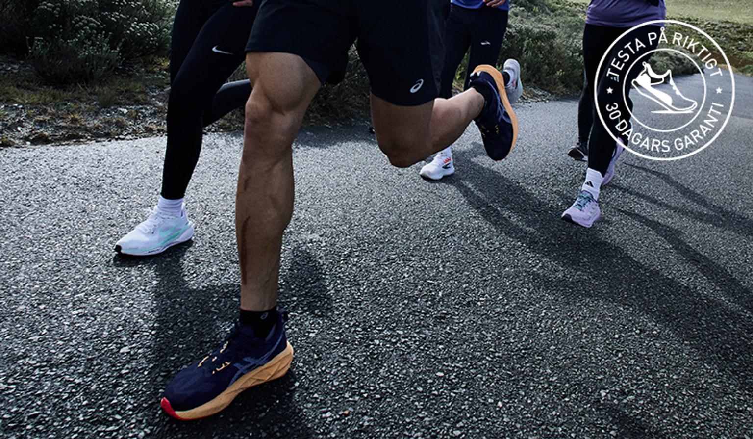 a group of people are running down a road .