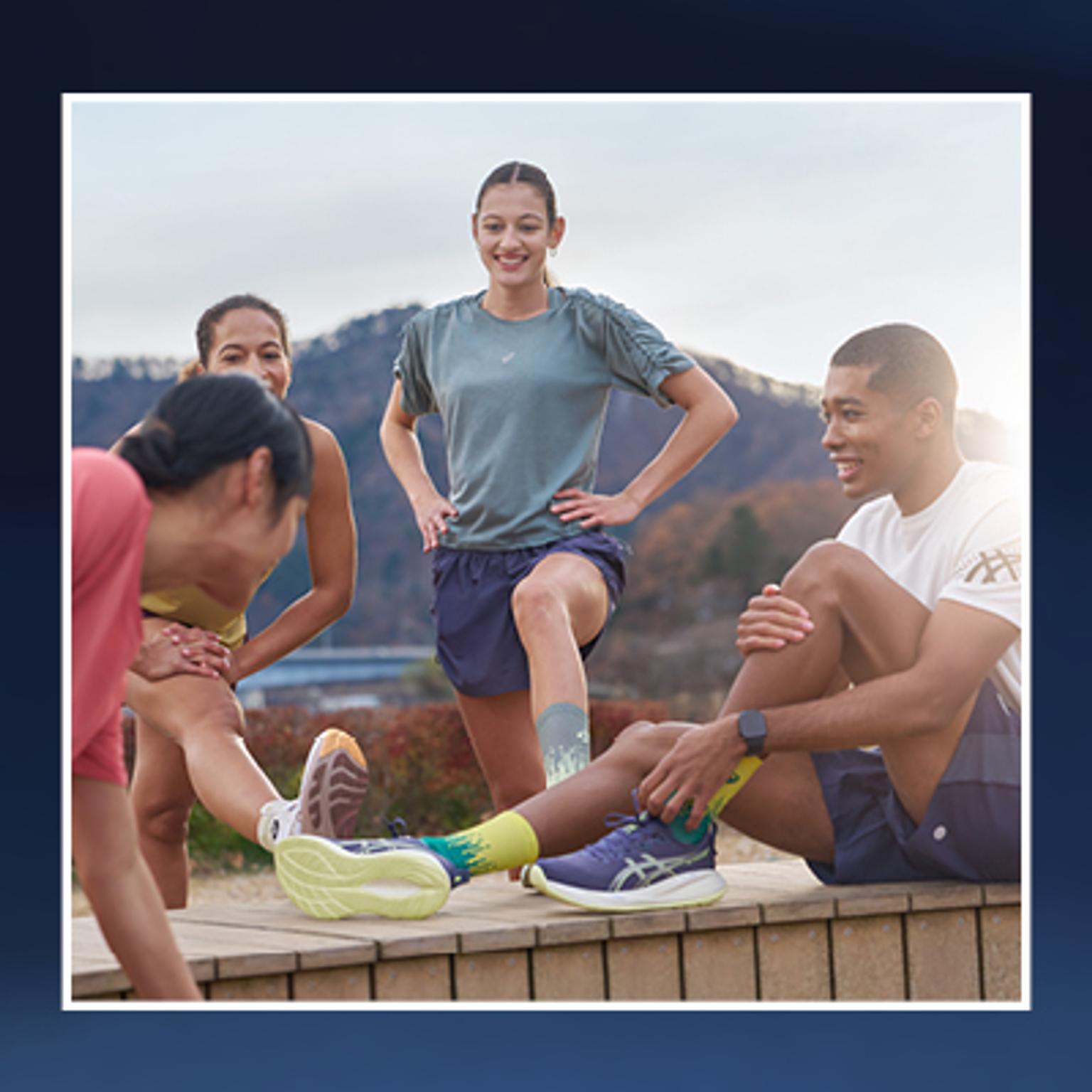 a group of people are stretching their legs on a wall .