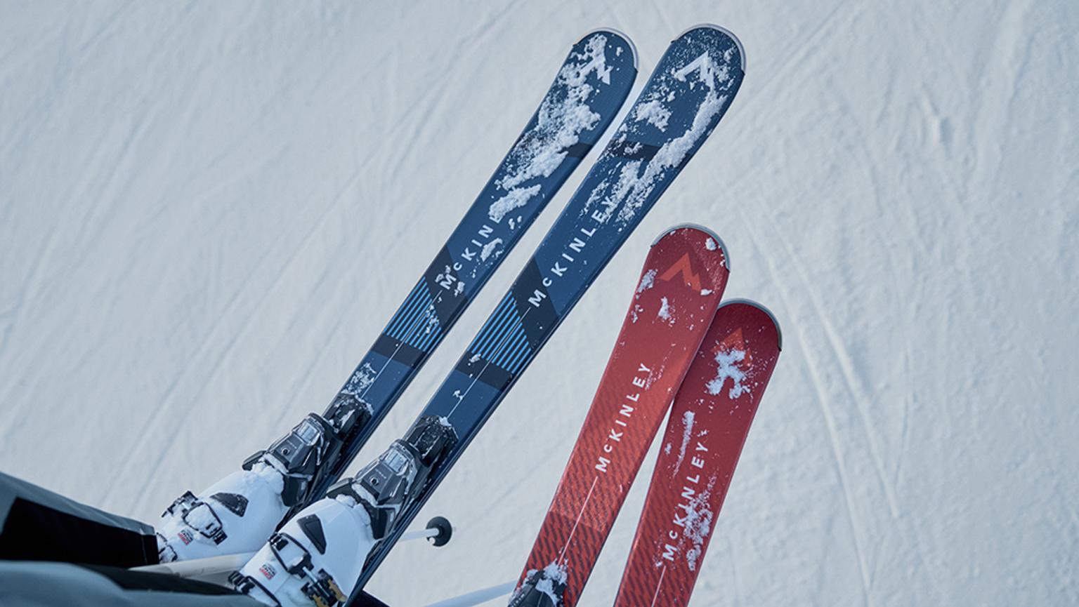 three pairs of skis are sitting on top of a snow covered slope .