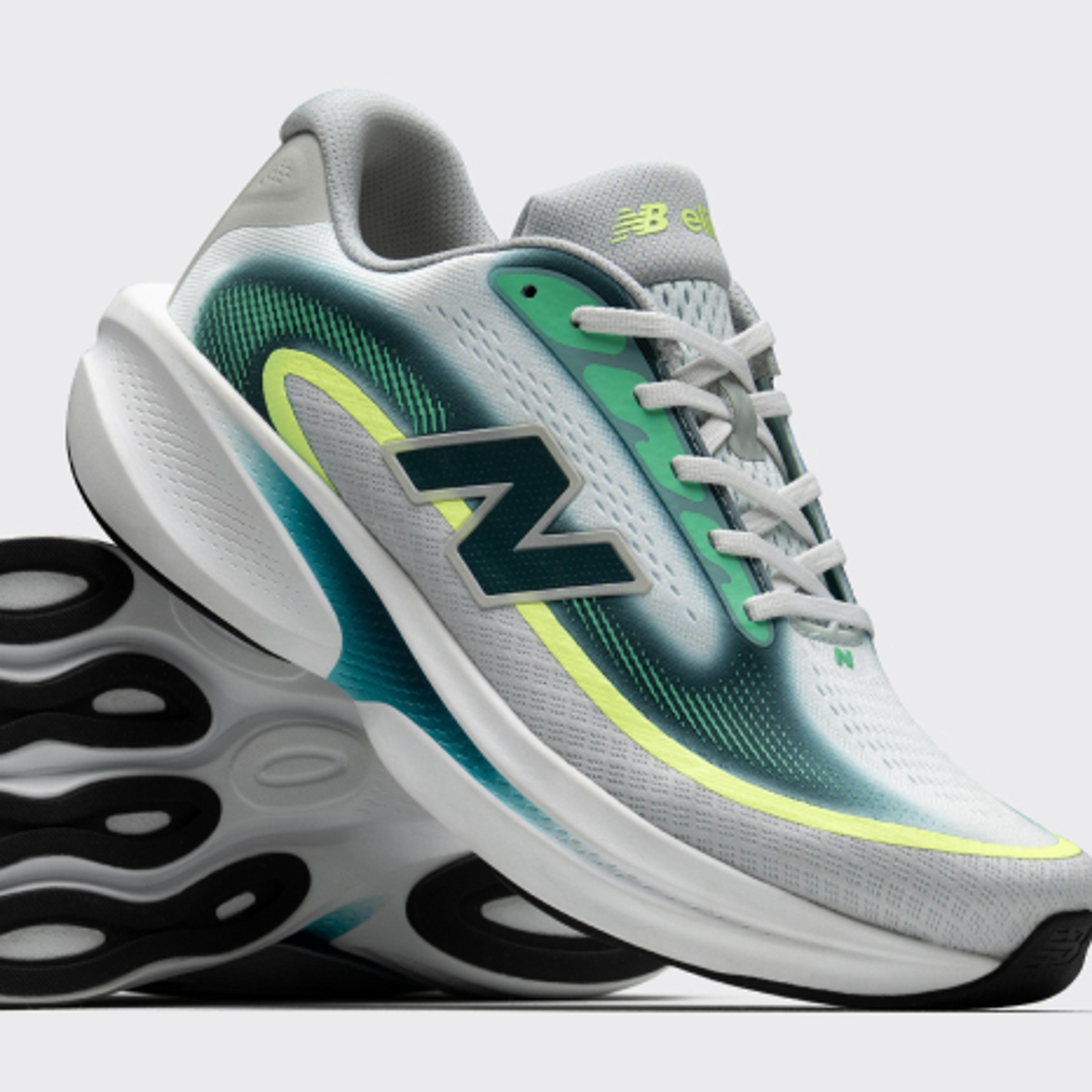 Light gray New Balance running shoes with teal and neon yellow accents, one shown upright and the other revealing its black and white patterned sole.