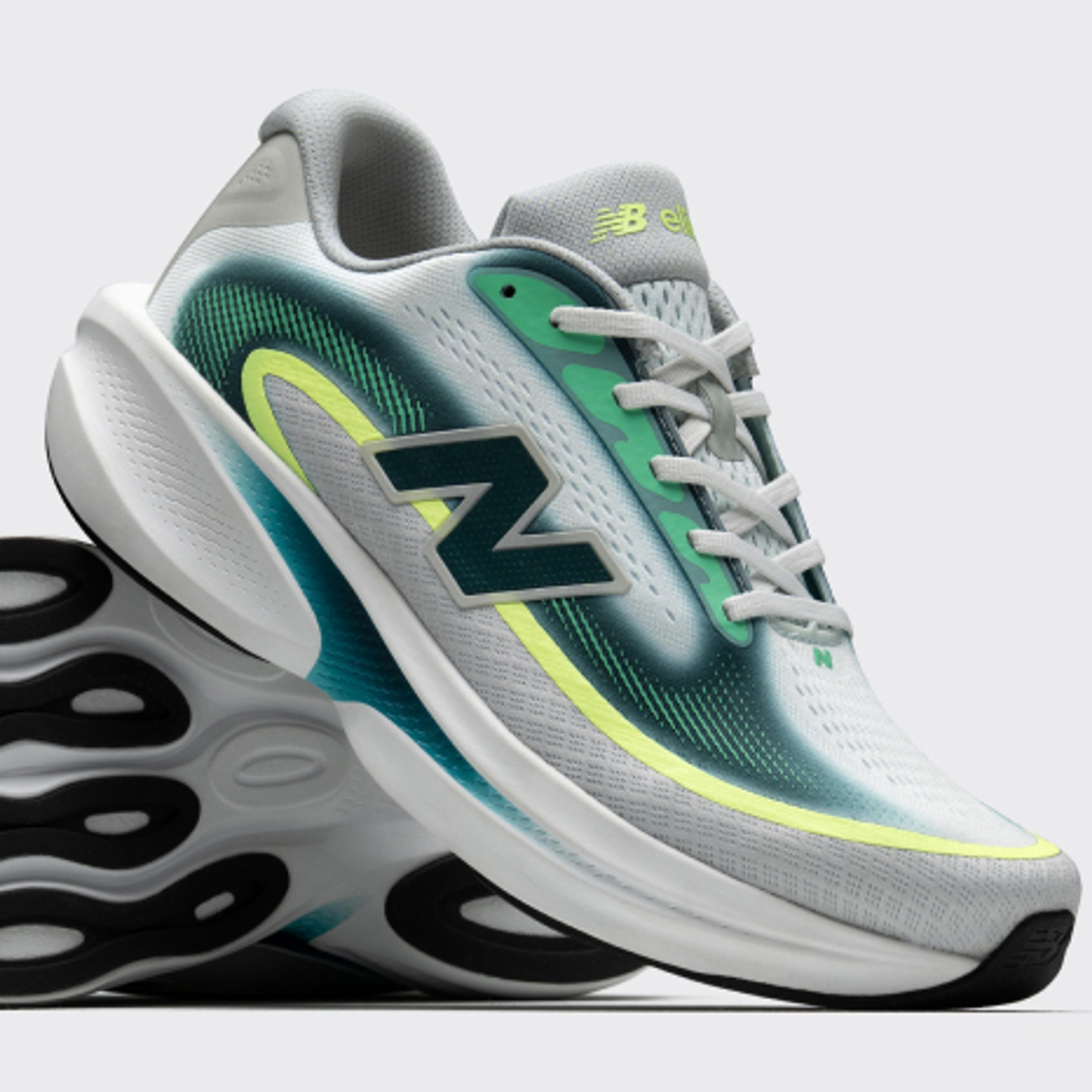 A pair of grey and white New Balance running shoes with teal and lime green accents. One shoe is tilted to show its black and white wavy sole.