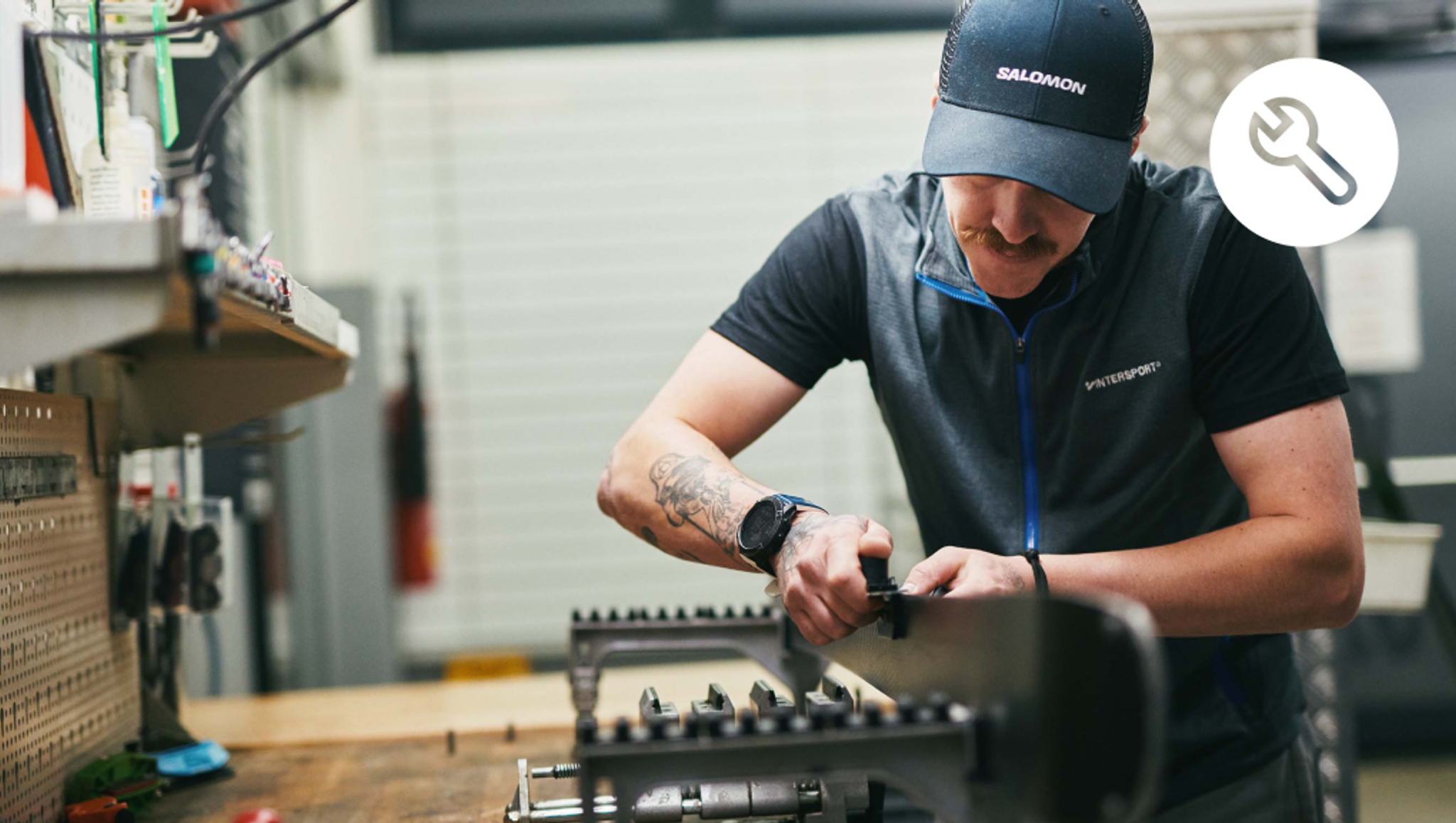 Ski technician working on a ski in a workshop.