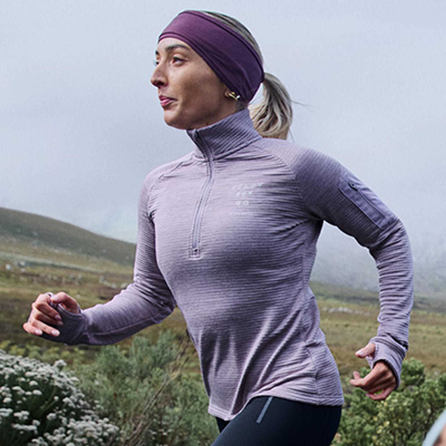 tjej som är ute och springer i löparjacka