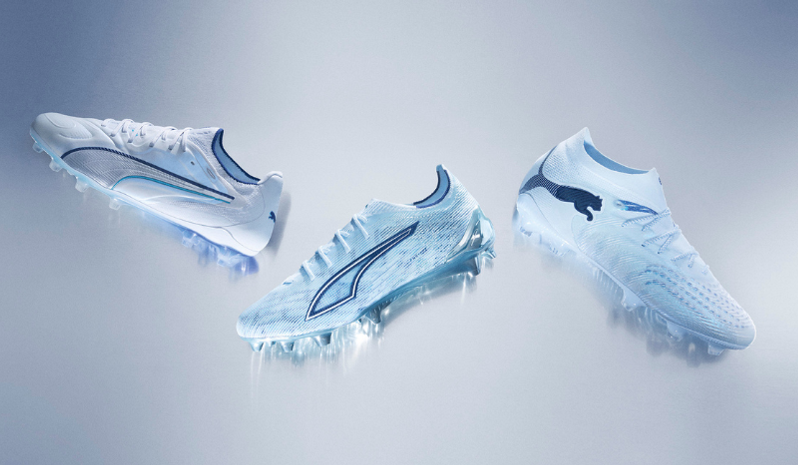 Three white and light blue Puma soccer cleats with an icy, glowing effect.