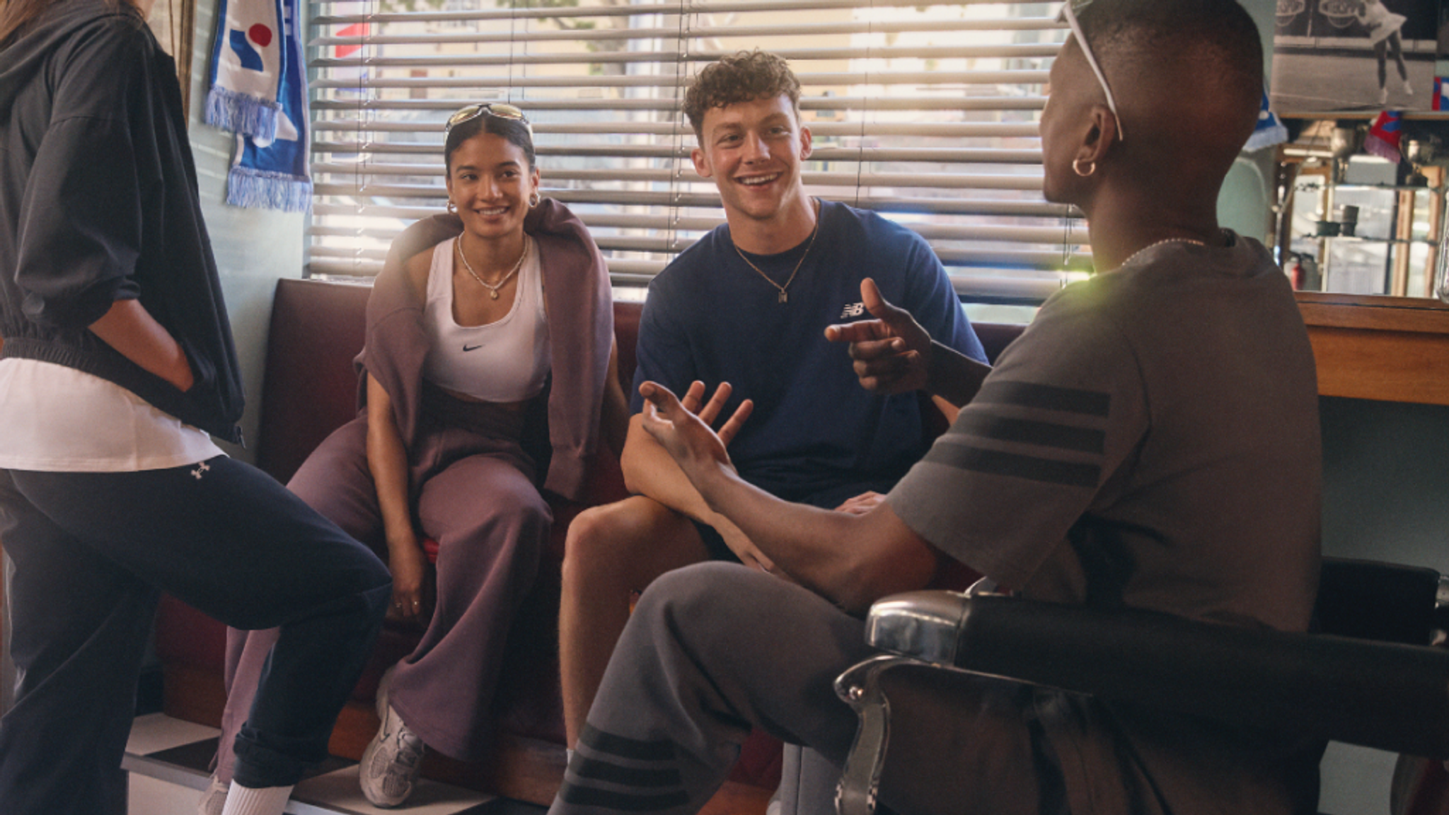 A group of friends smiling and conversing in a barbershop.