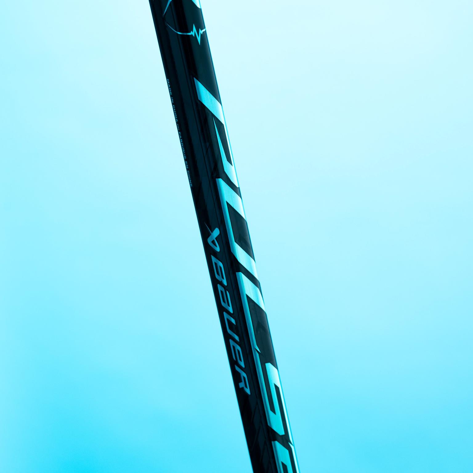 Black Bauer Hyperlite hockey stick with reflective blue branding against a light blue background.