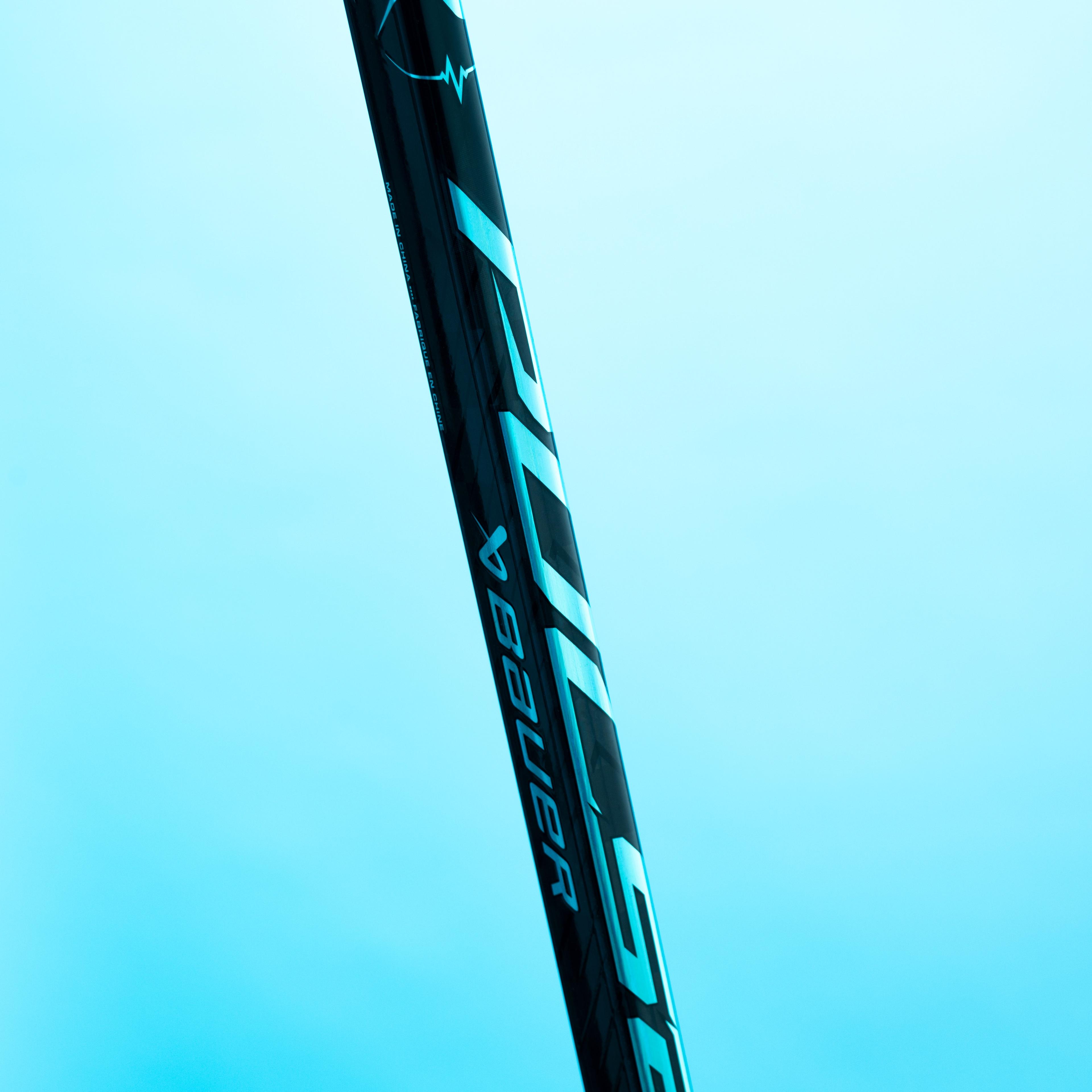 Black Bauer Hyperlite hockey stick with reflective blue branding against a light blue background.