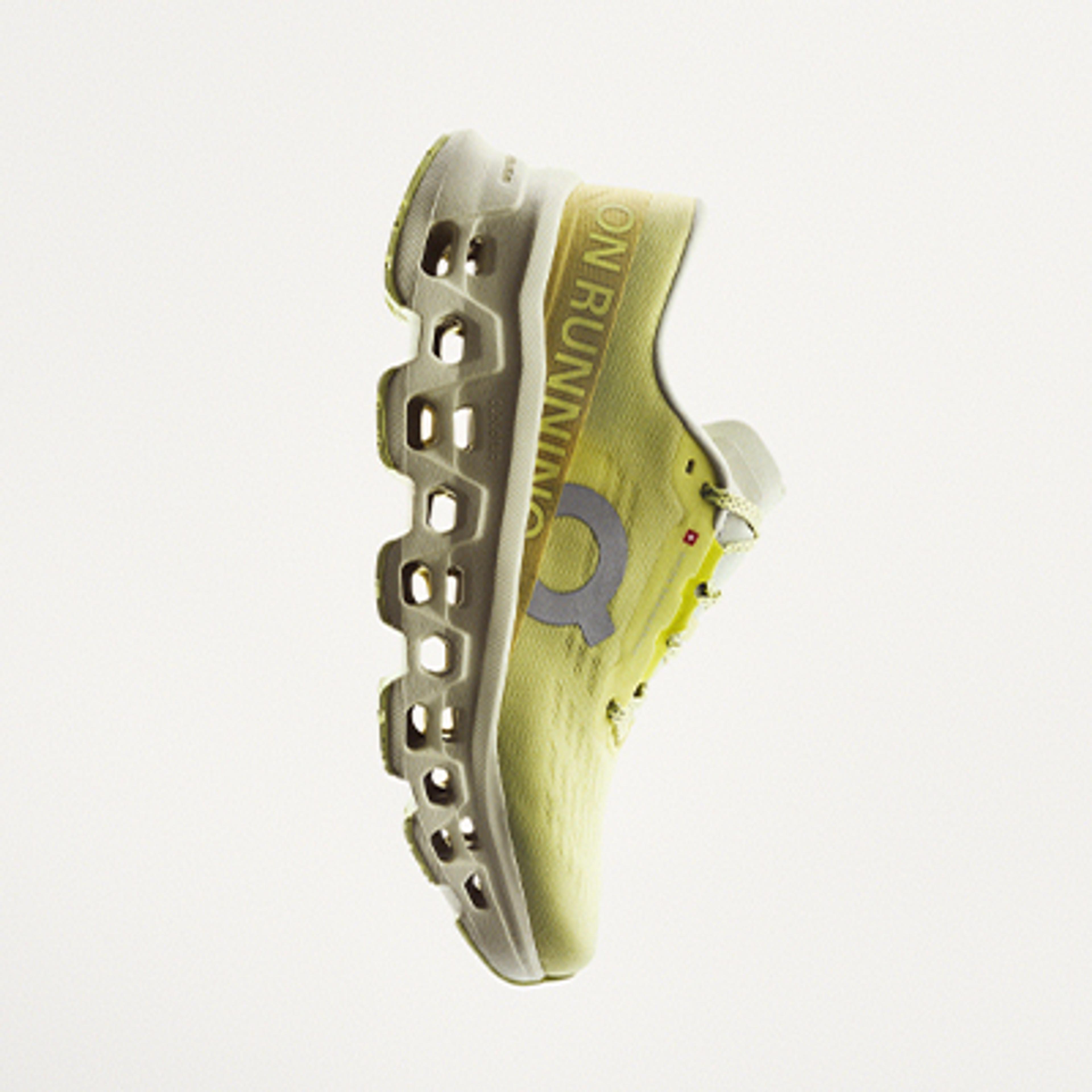 A light yellow On running shoe with a segmented sole.