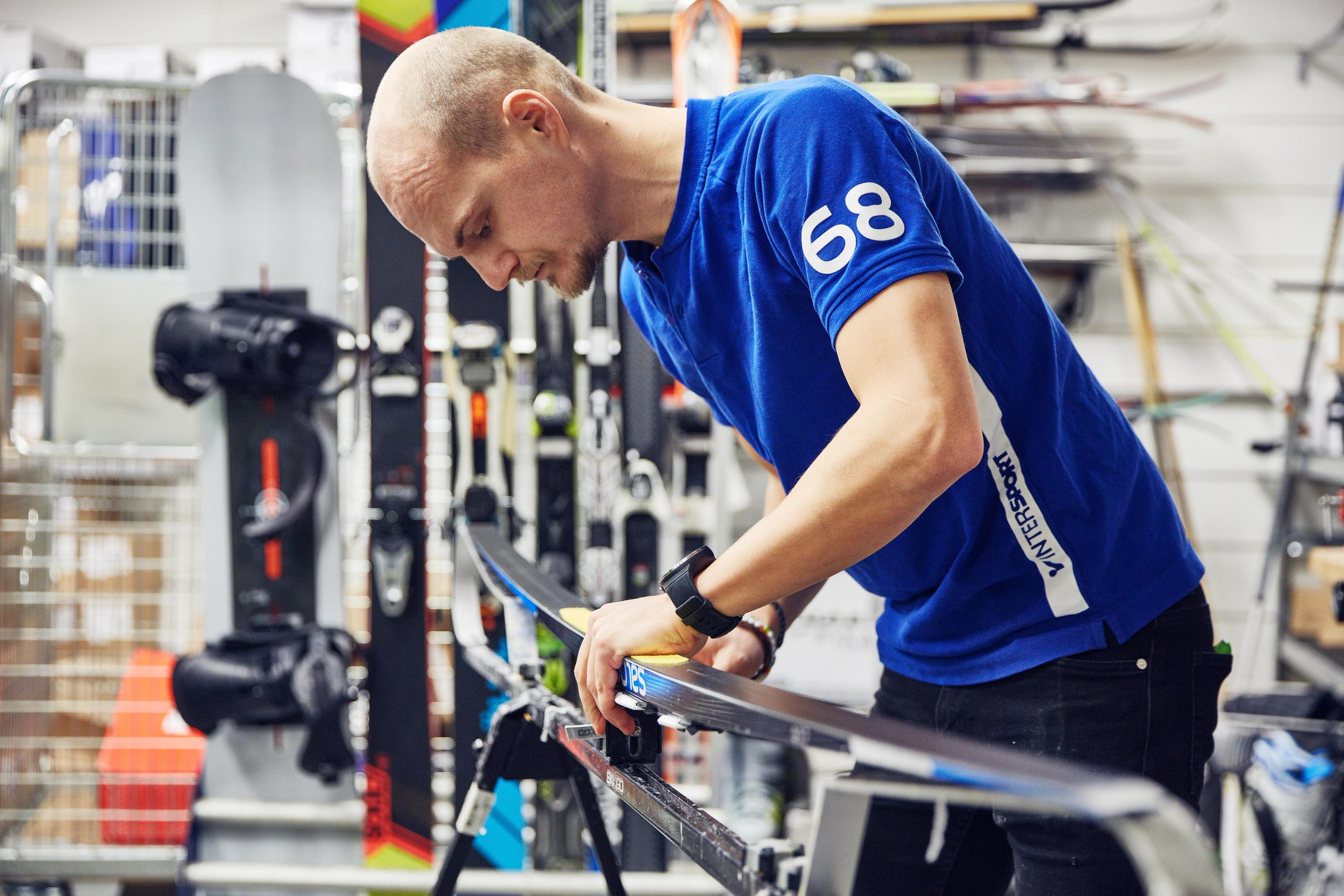 A man tuning a ski in a workshop.