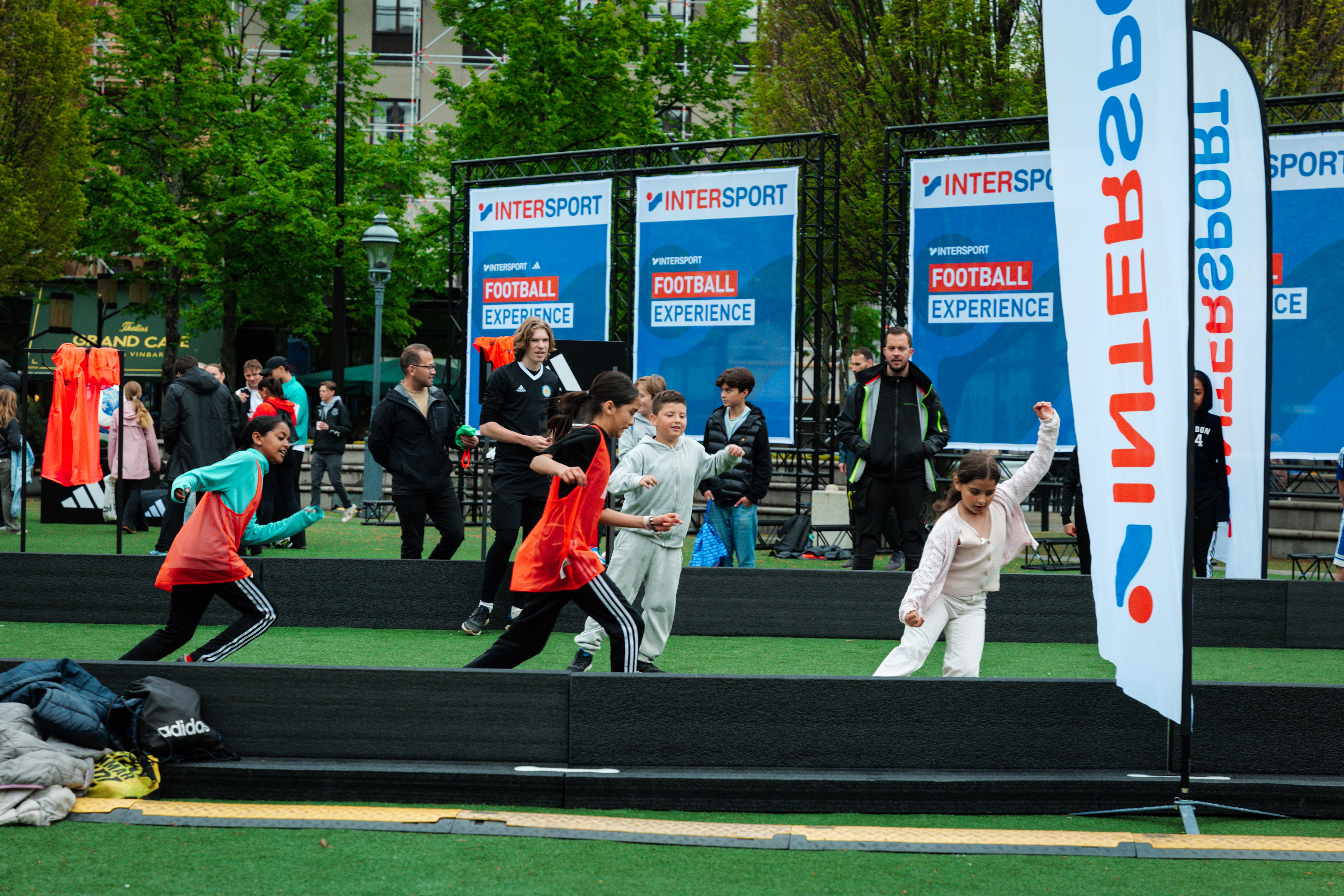 Children participate in an Intersport Football Experience event on an artificial turf field.