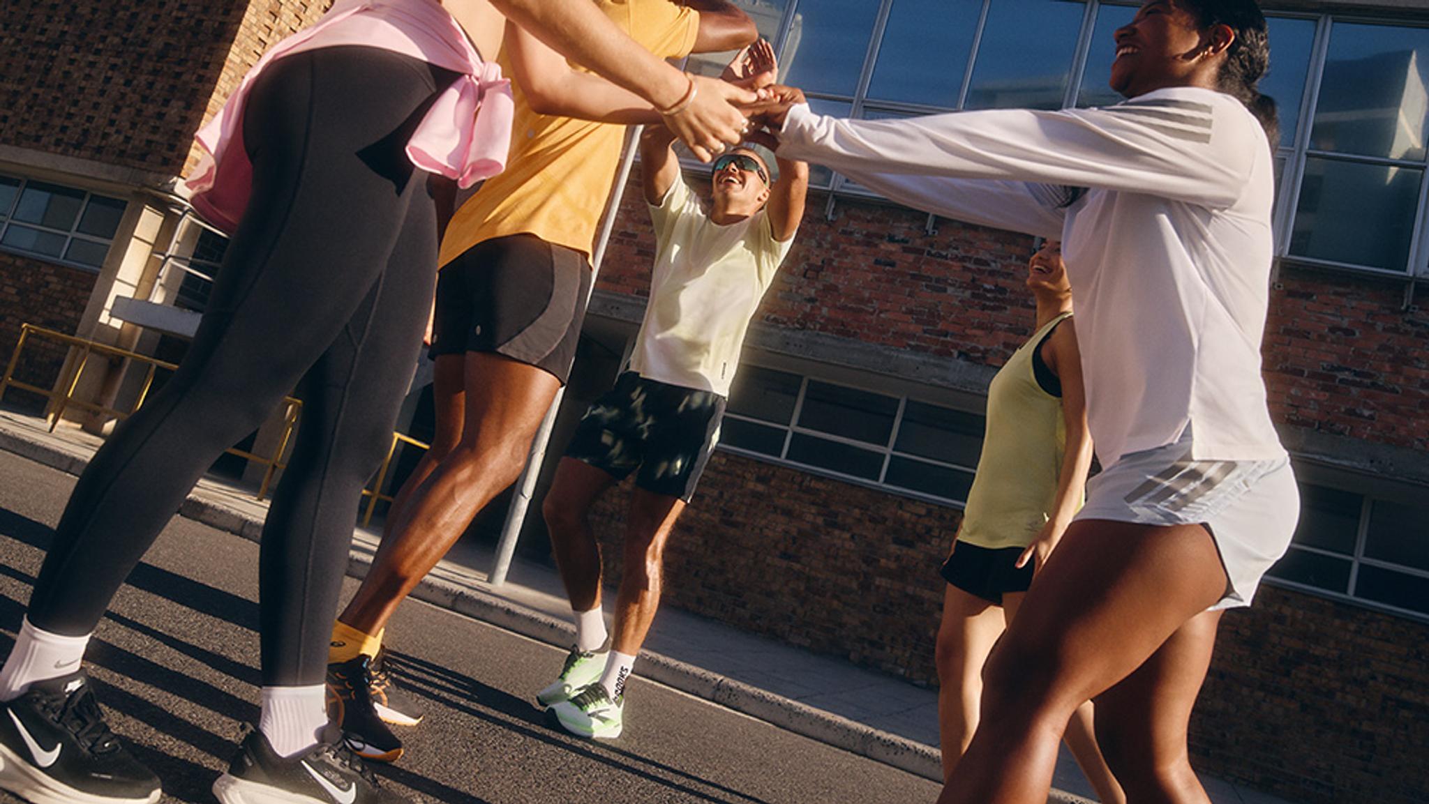 a group of people are running down a street in cold weather .