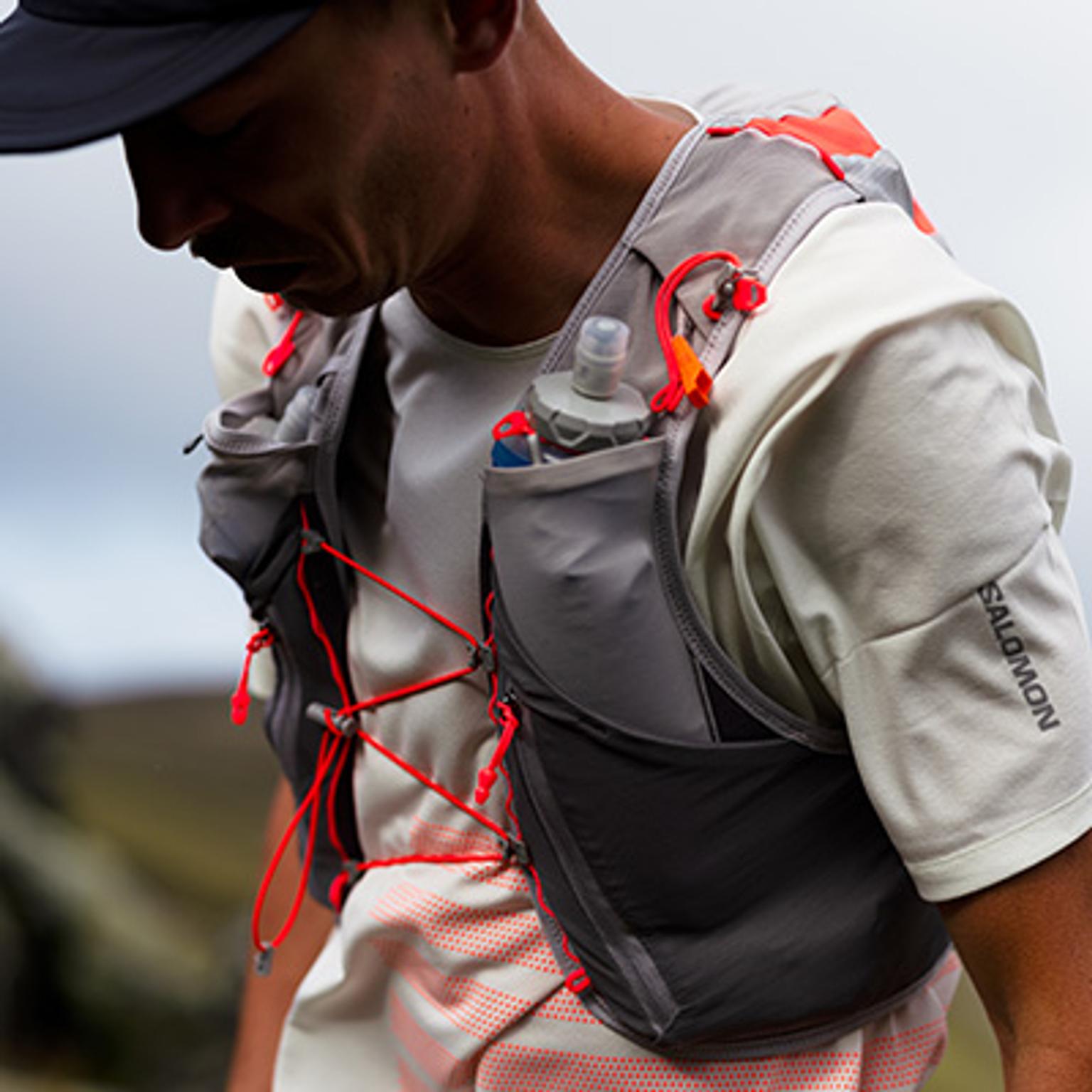 a man is wearing a backpack with a water bottle in it .