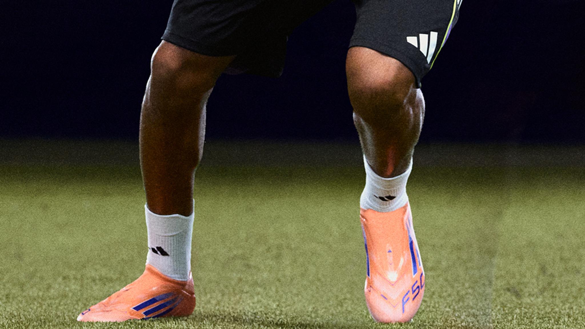 a close up of a person wearing soccer cleats on a field .