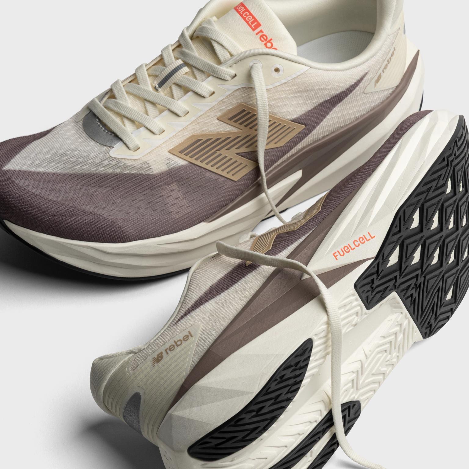 a pair of white and brown running shoes on a white surface .