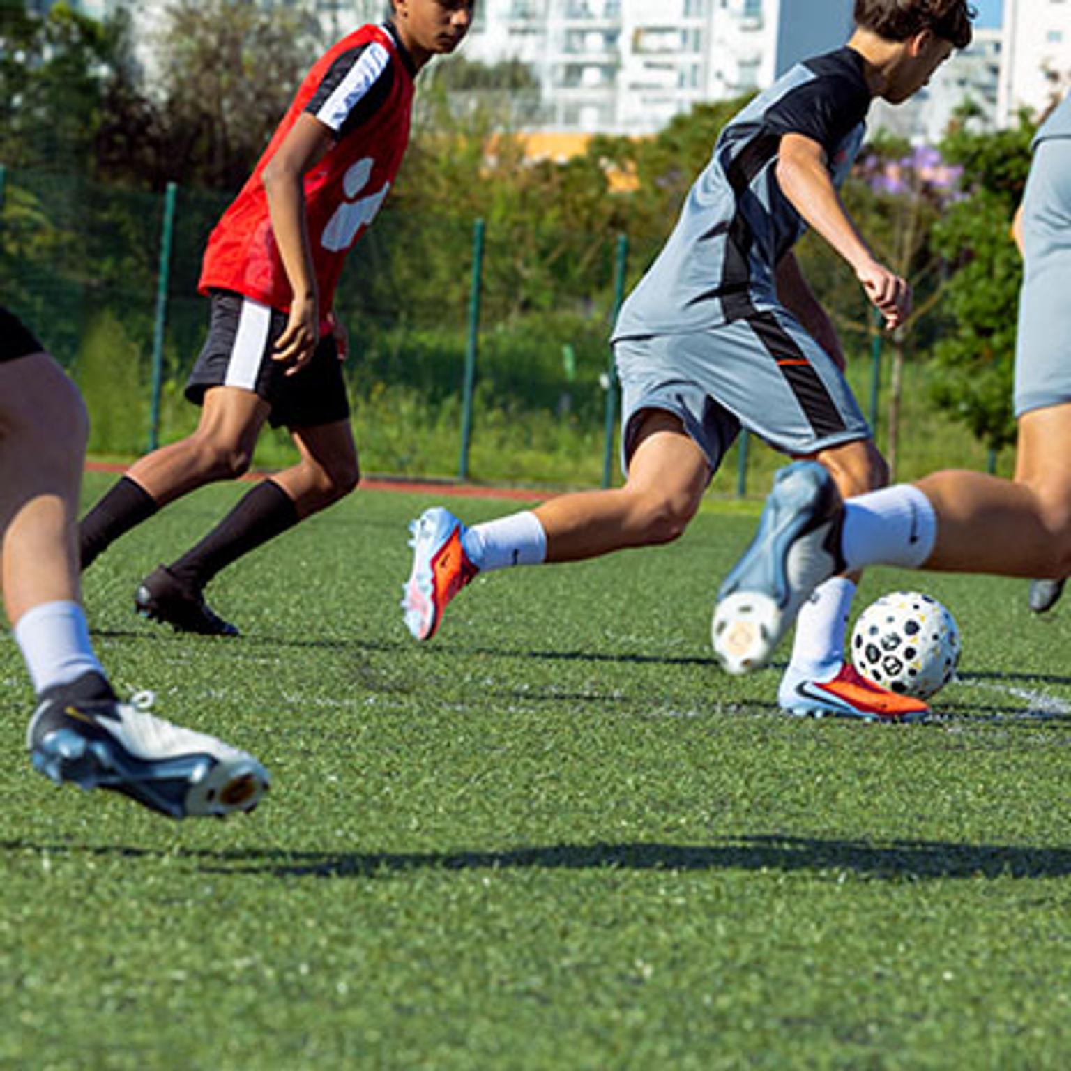 a group of young men are playing soccer on a field .