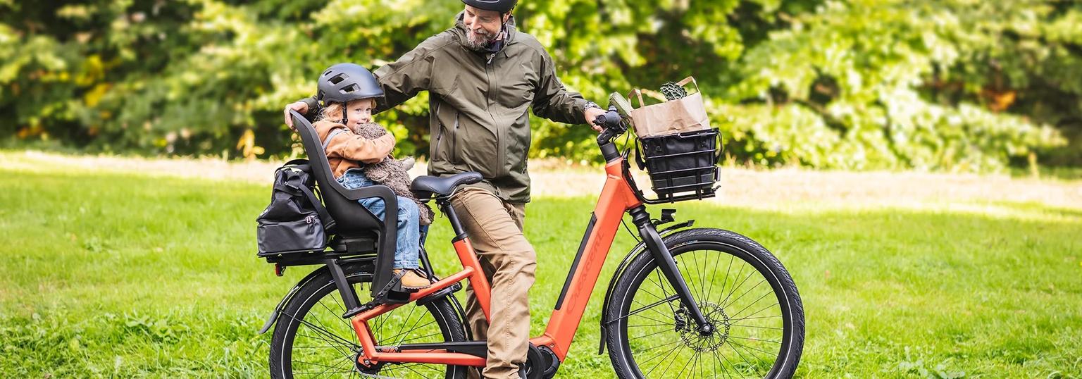 Kille som ska cykelpendla med elcykel och cykelhjälm