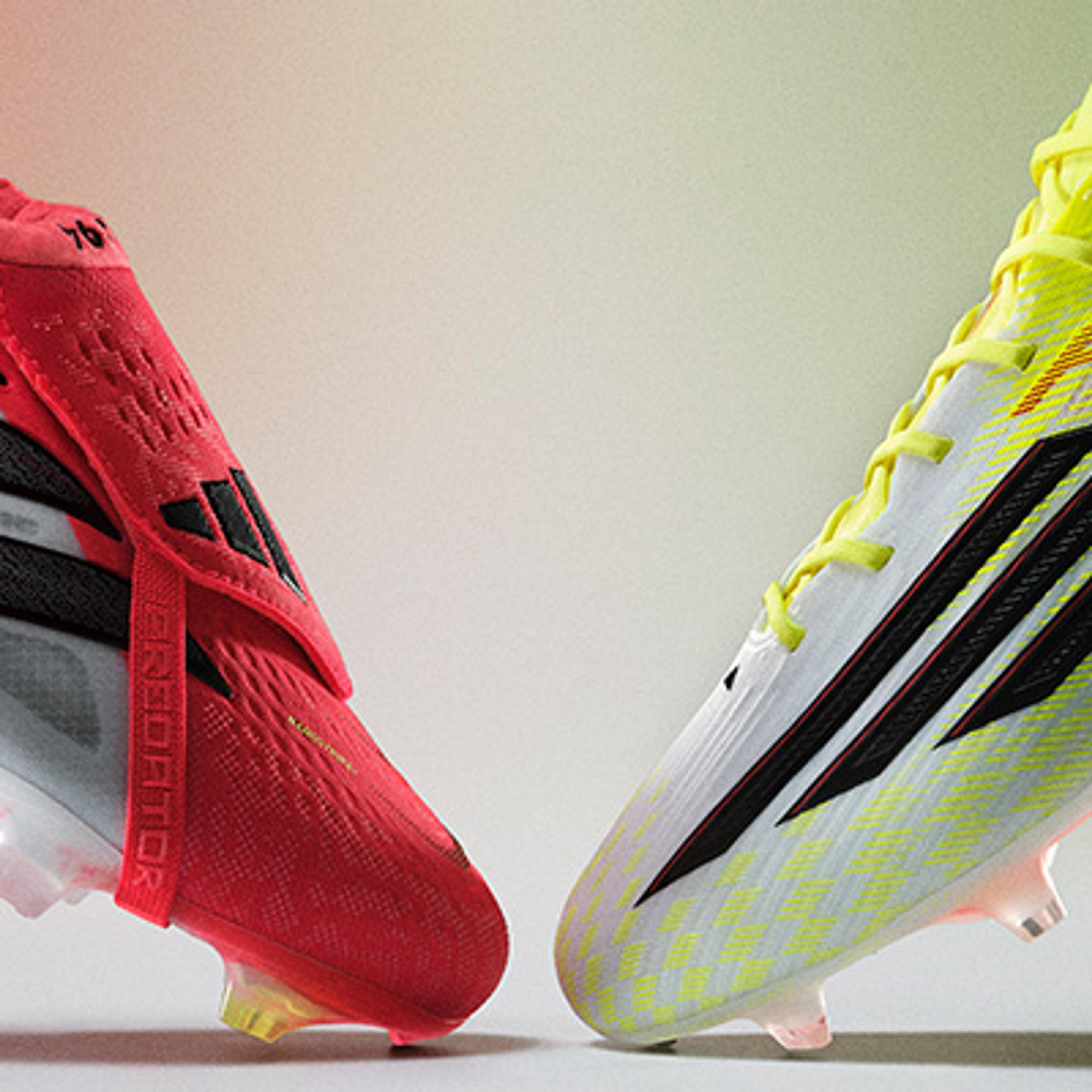Two Adidas soccer cleats, one red and one white/yellow, facing each other.