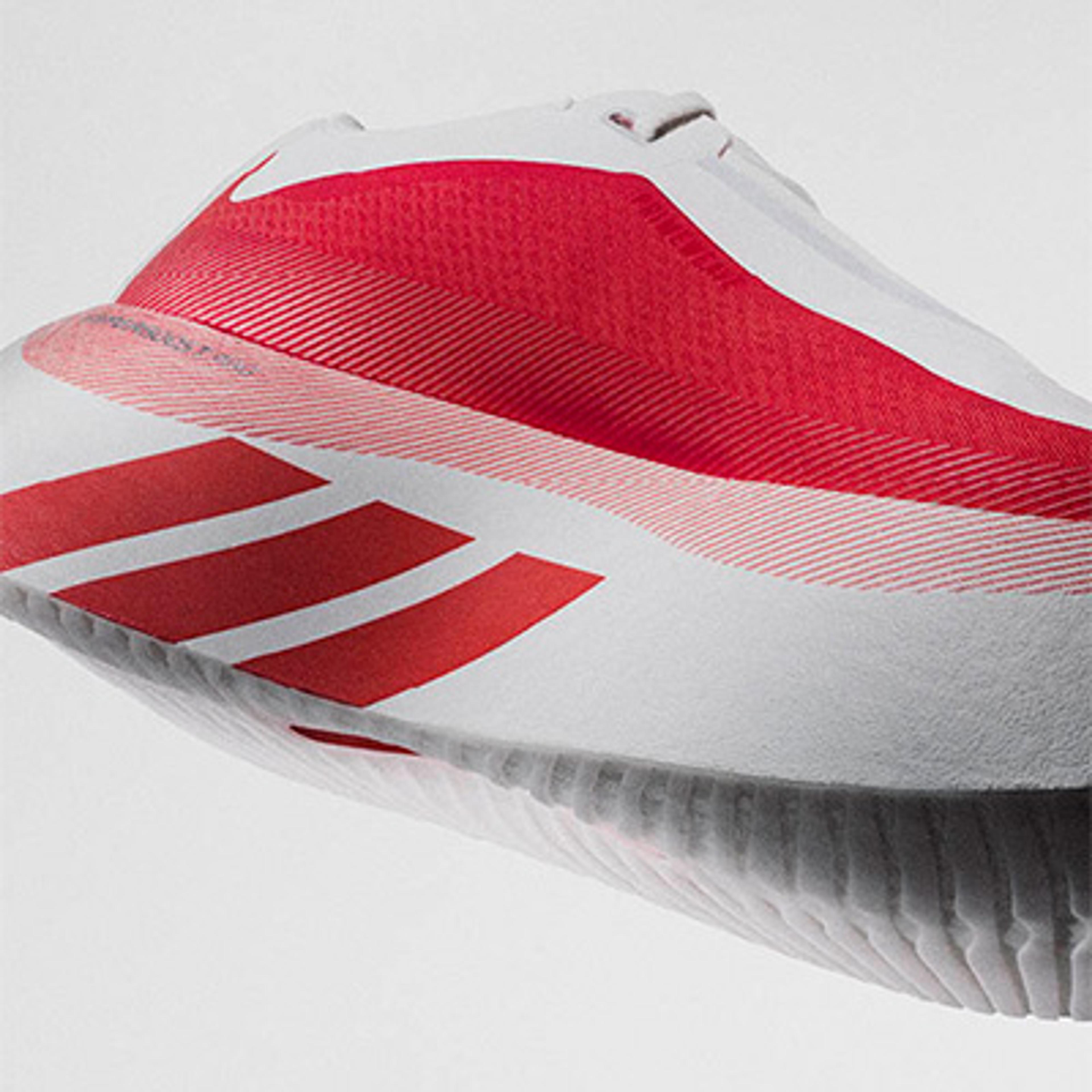 White Adidas shoe with red stripes and a textured sole.