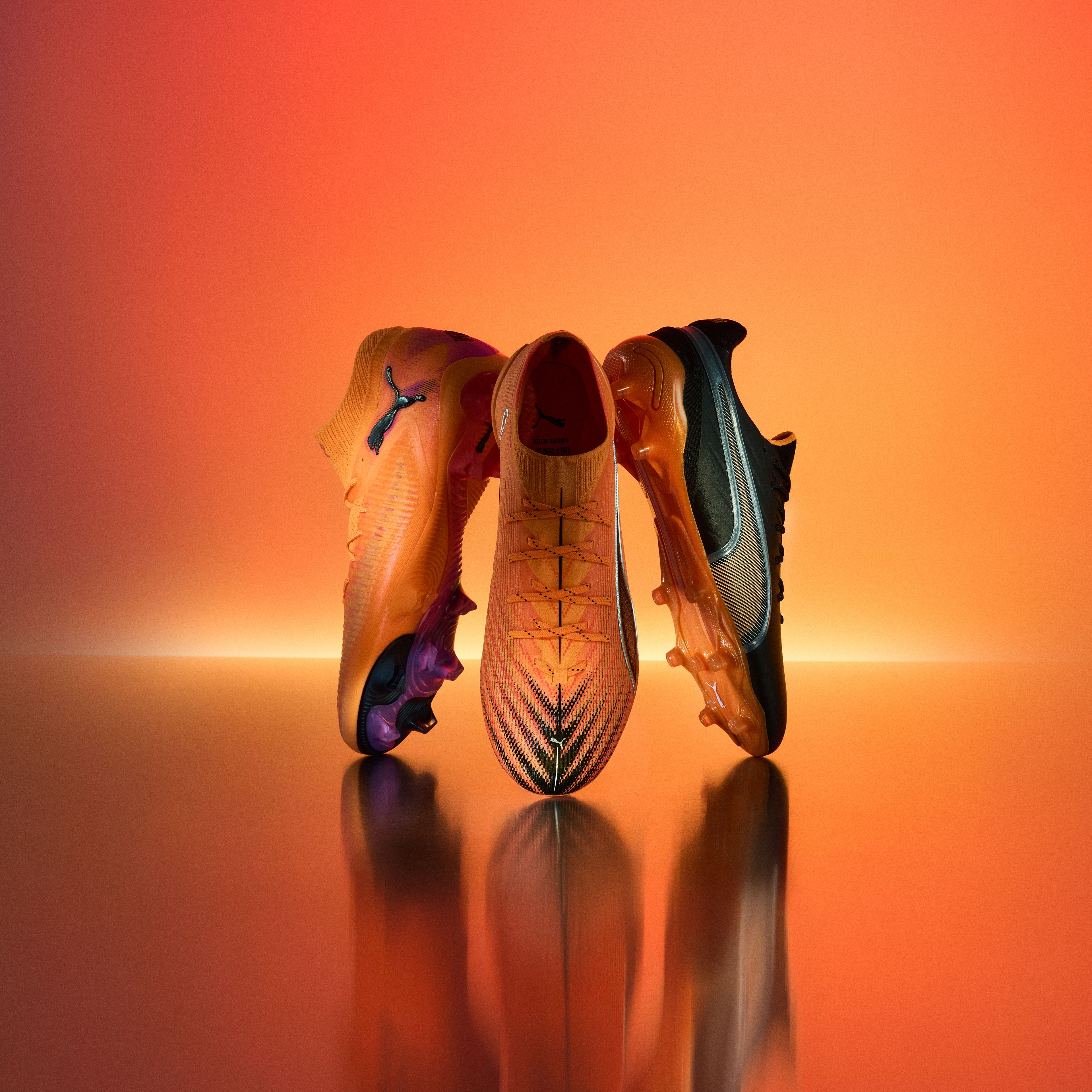 three pairs of soccer cleats are sitting on top of each other on a table .