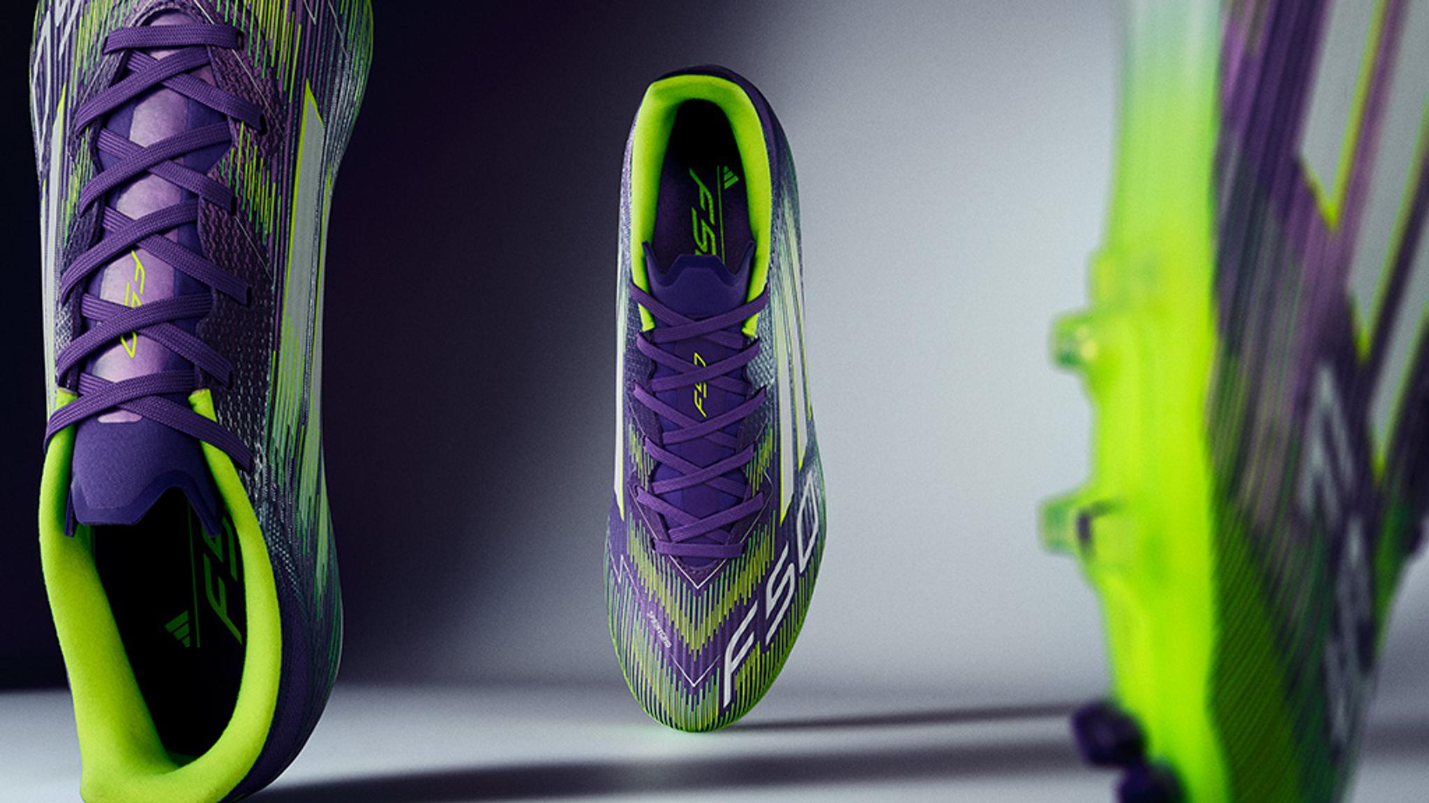 a pair of purple and yellow soccer cleats are floating in the air .