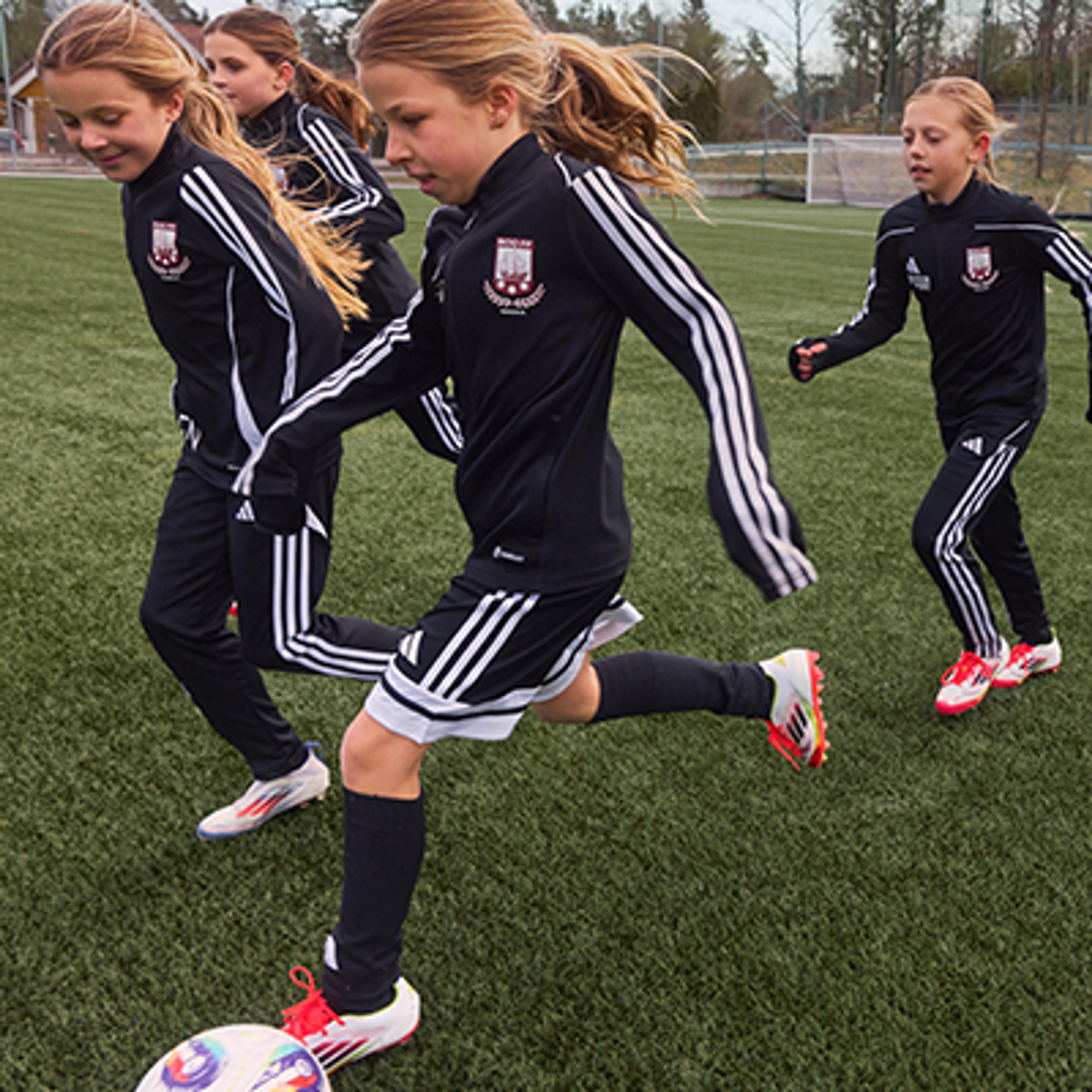 a group of young girls are playing soccer on a field .