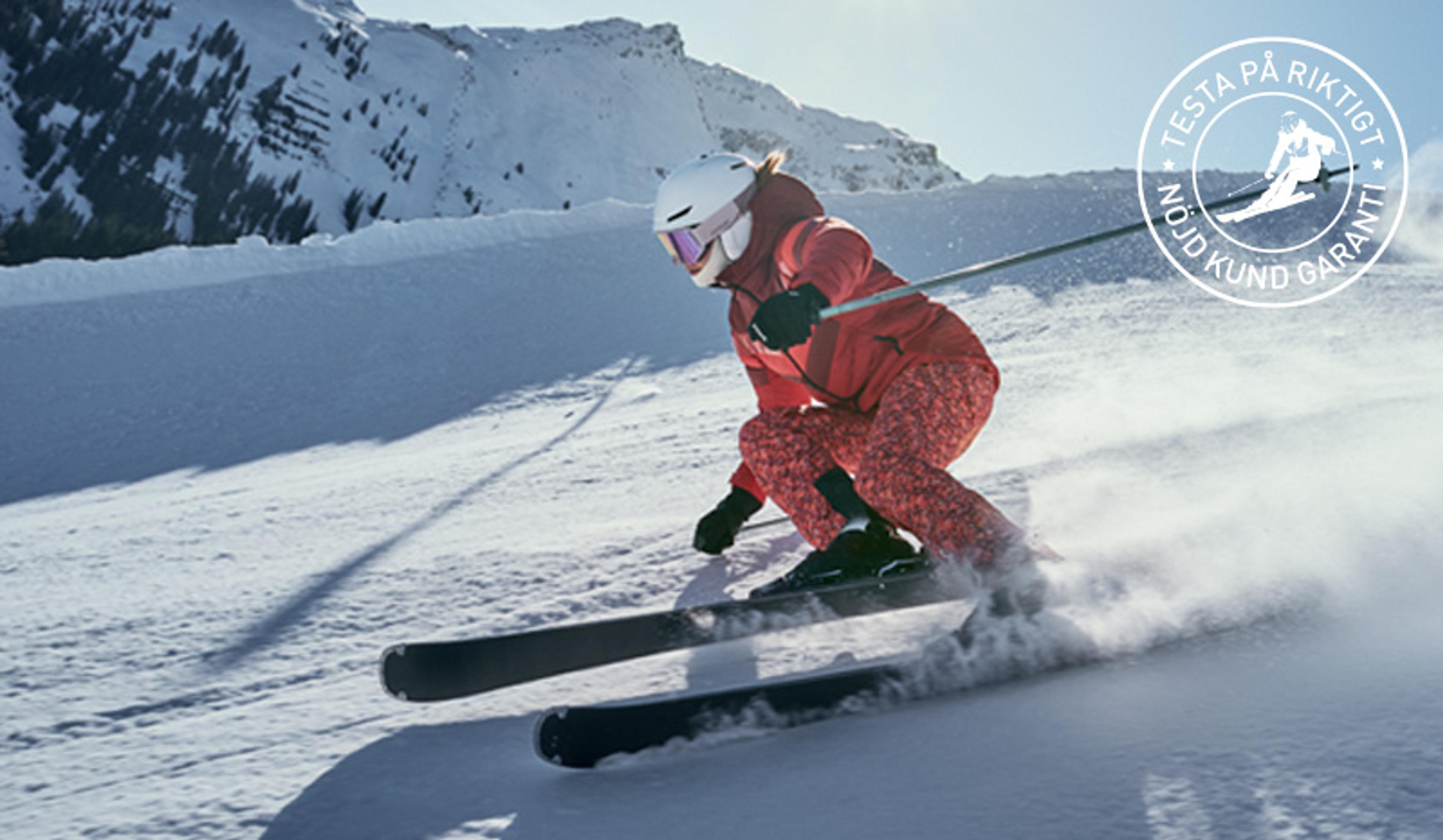 Skier in red carving on snowy mountain with 'Satisfied Customer Guarantee' badge.