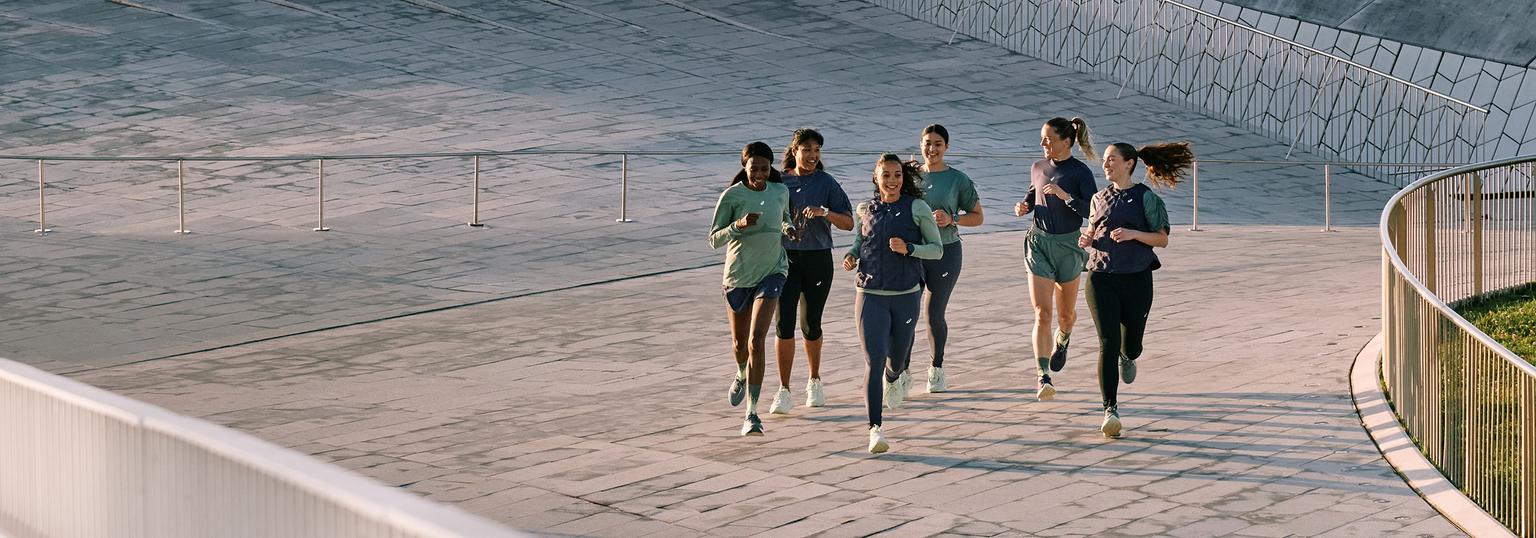 a group of people are running on a sidewalk .