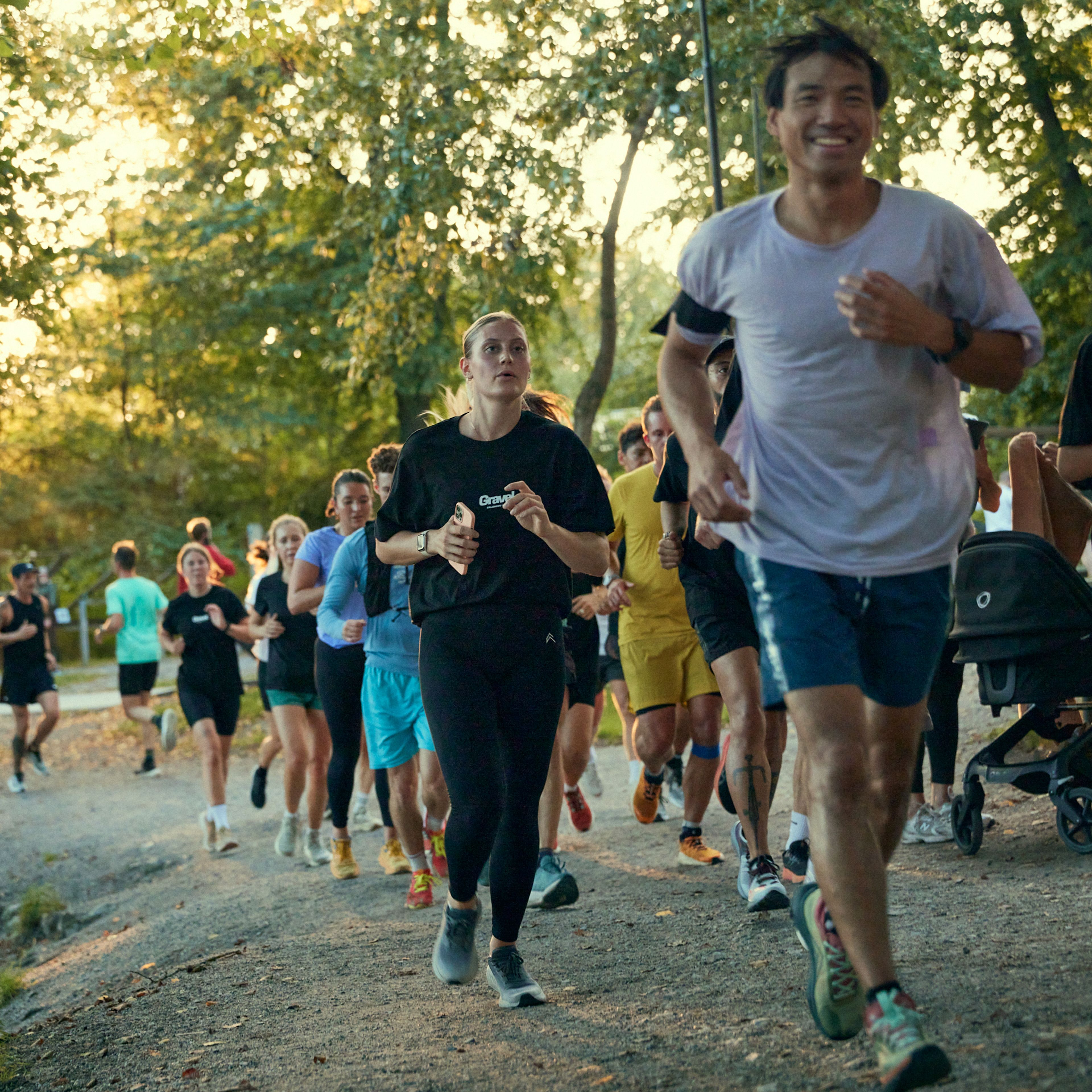 a group of people are running in a park .