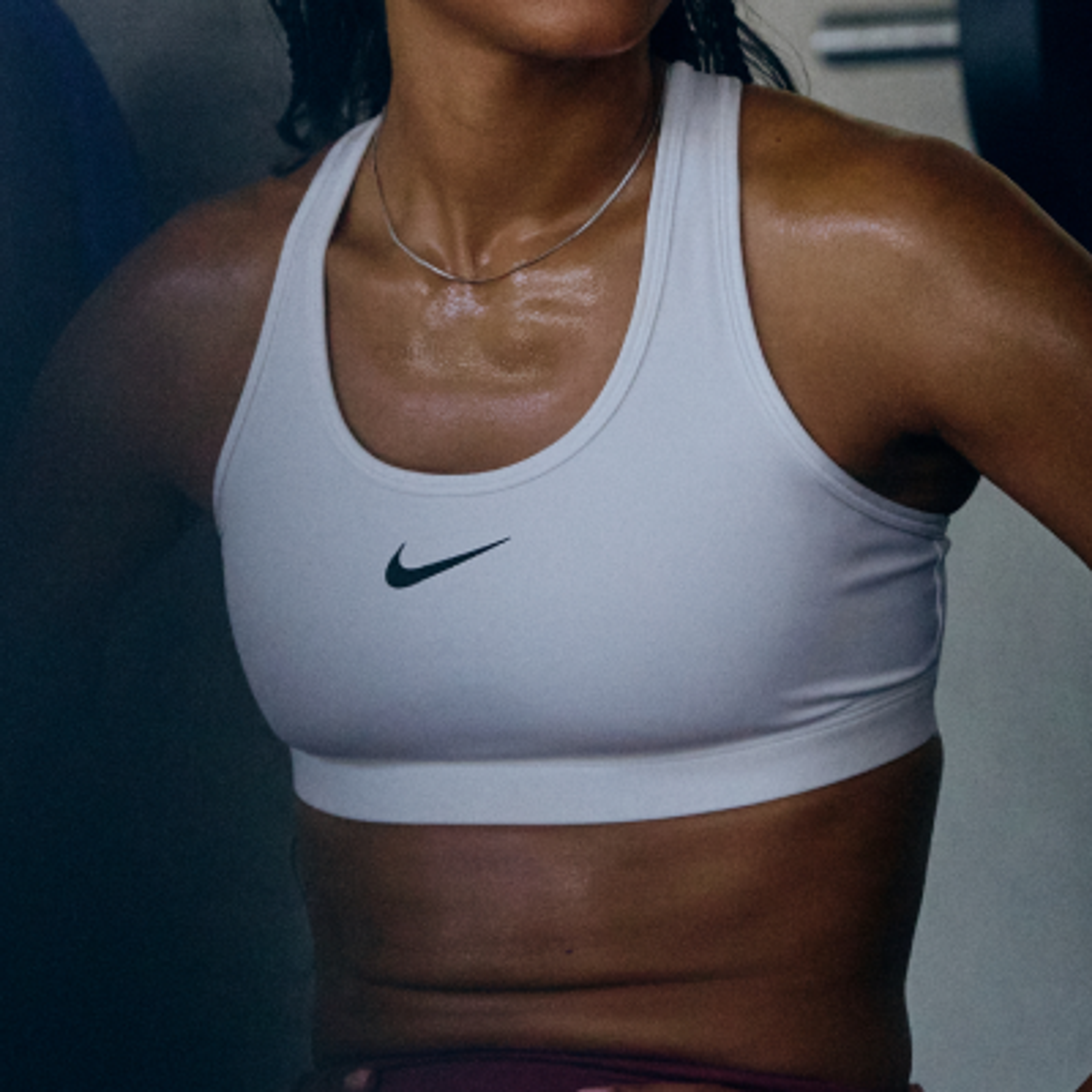 Sweaty person wearing a white Nike sports bra.