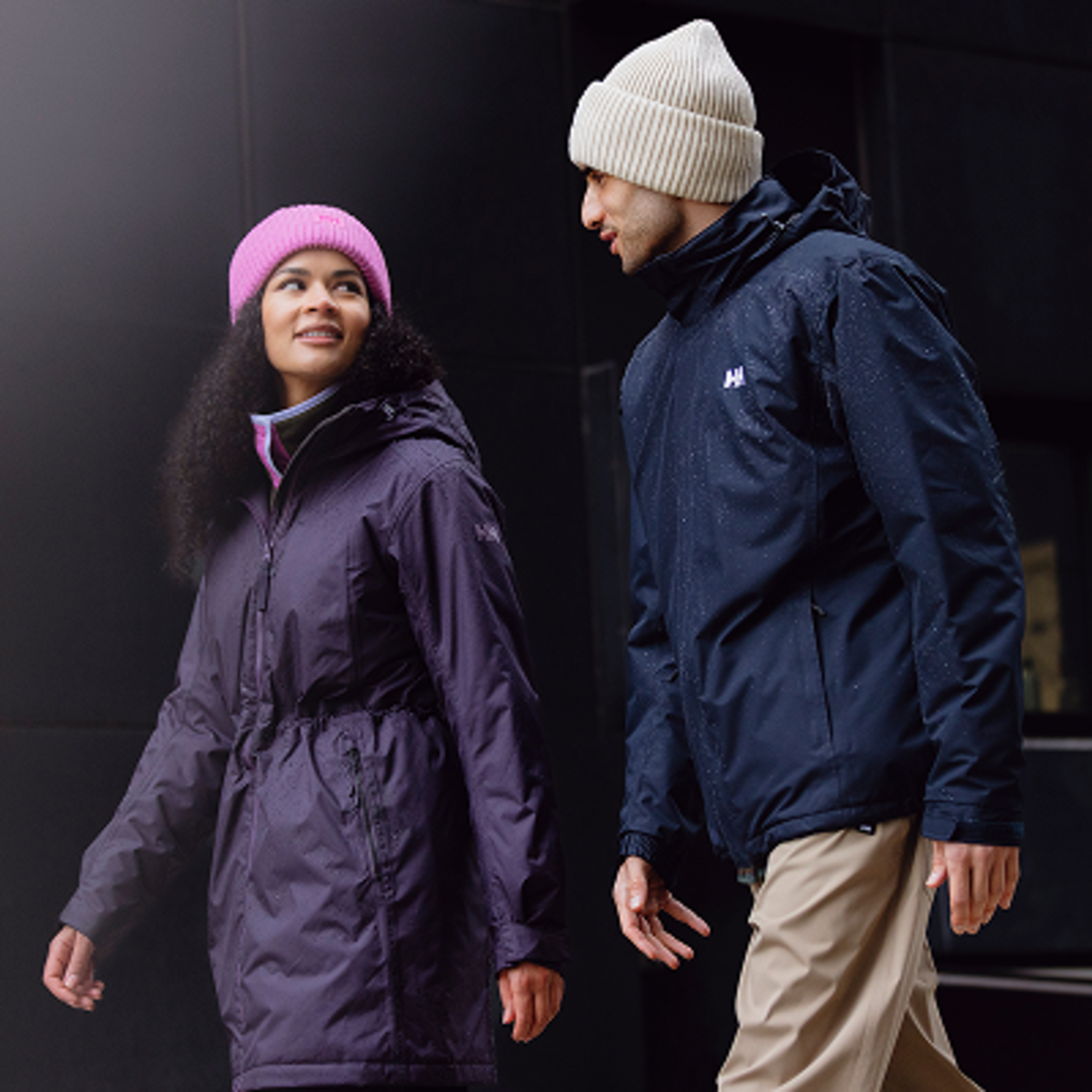 a woman wearing a pink hat and a man wearing a jacket with the letter h on it