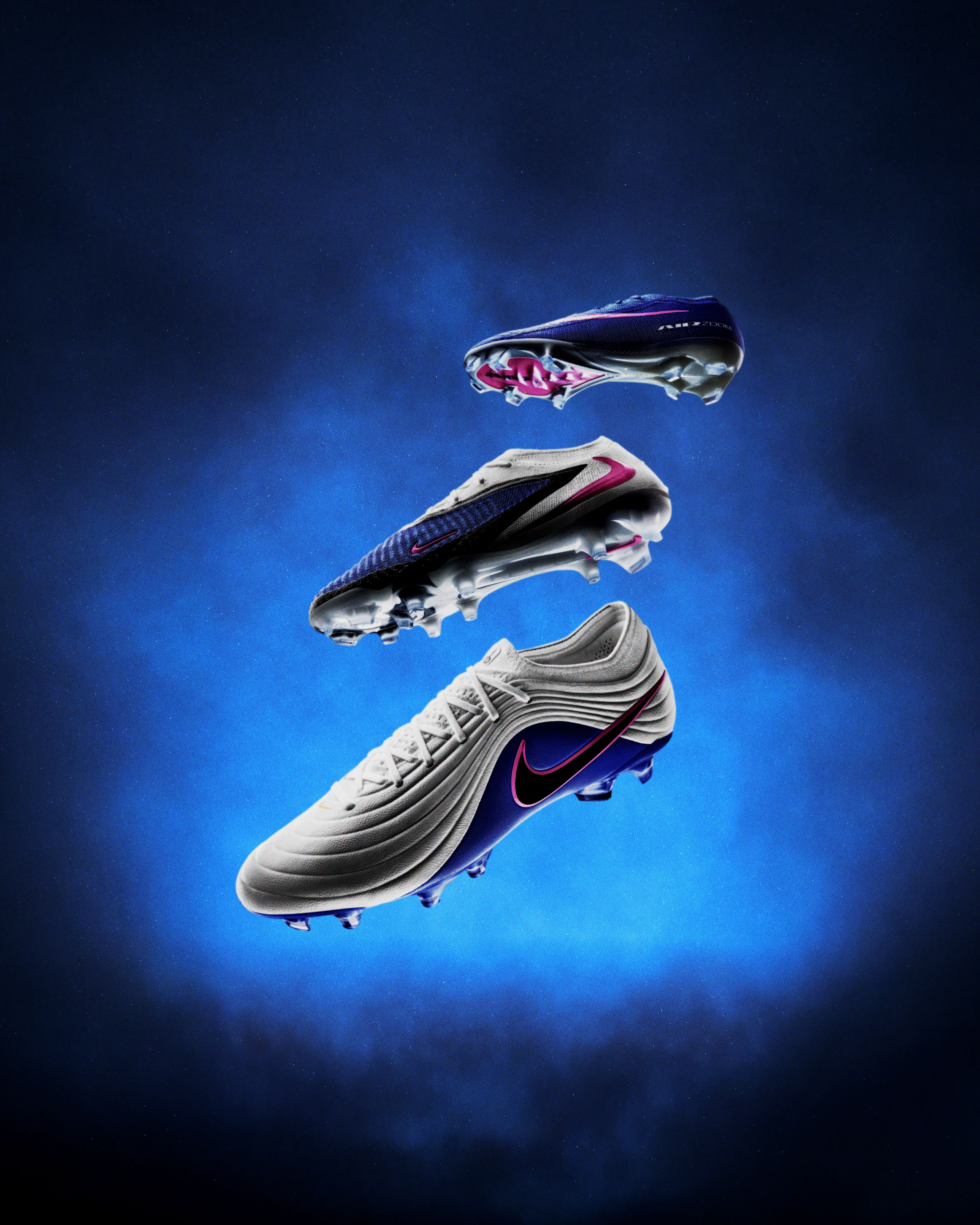 Three Nike soccer cleats of different designs, floating against a smoky blue background.